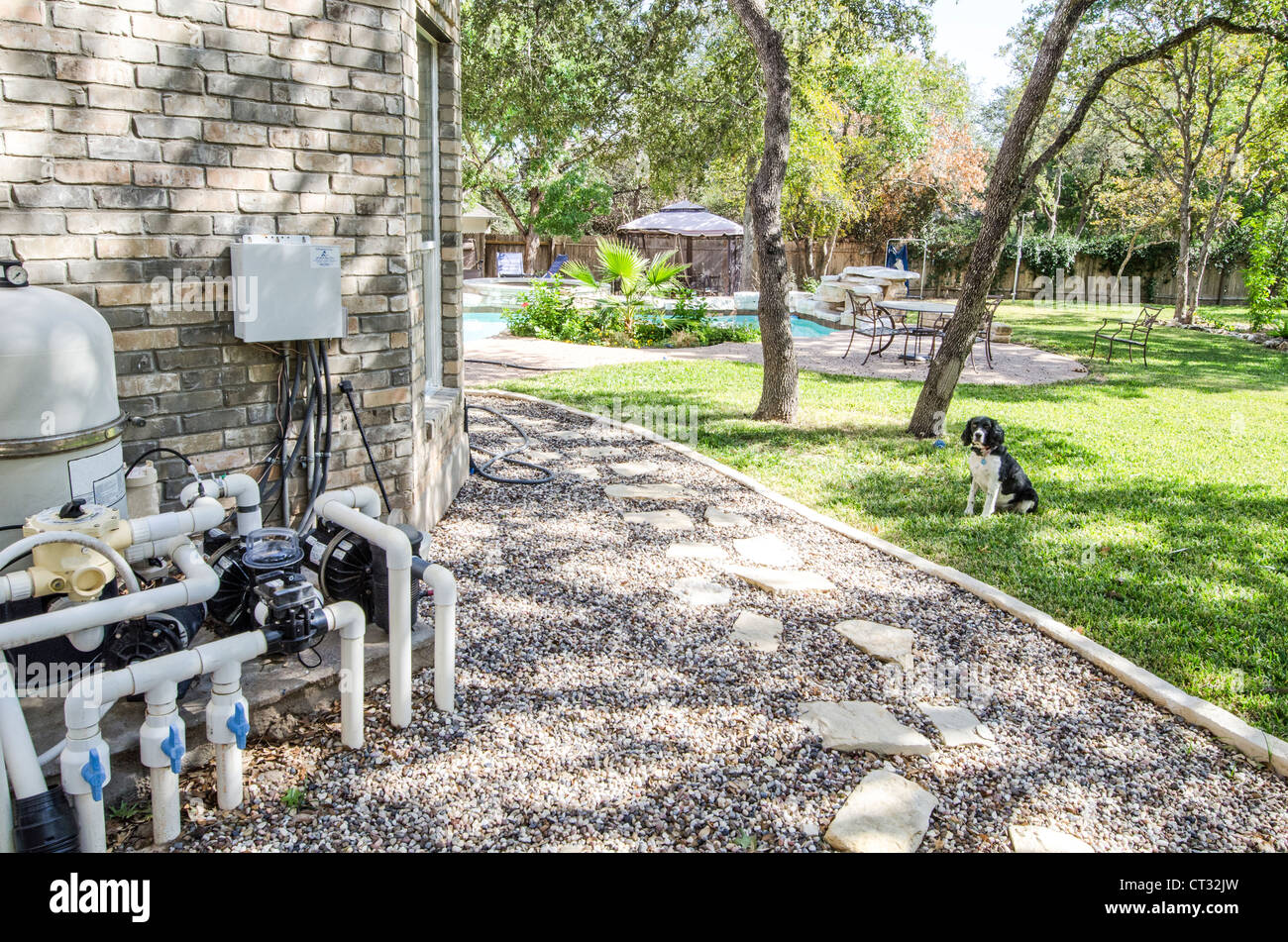 Swimming Pool water temperature and system control unit attached to side of house with view of