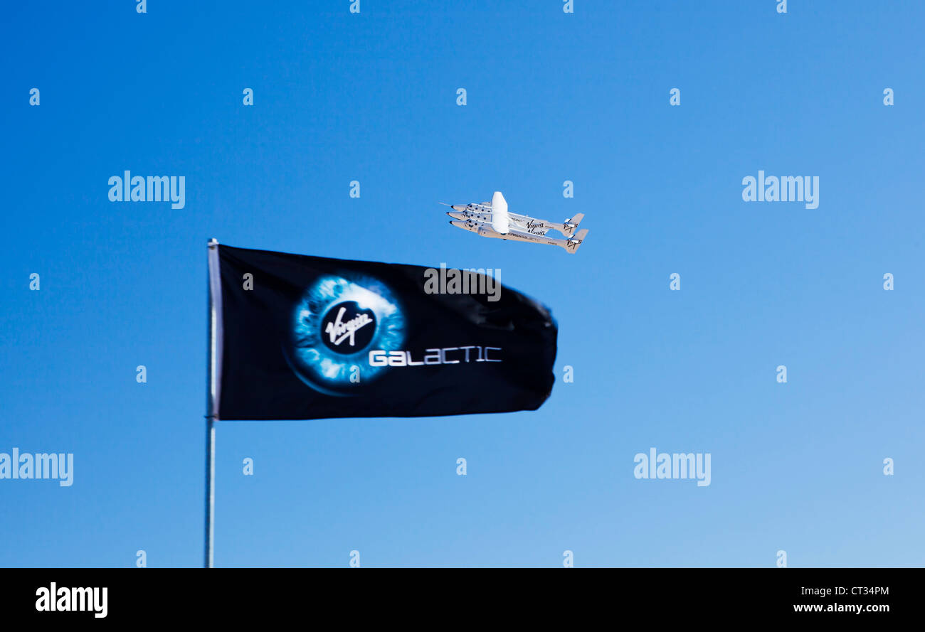 Virgin Galactic White Knight 2 with Spaceship 2 attached flying over Virgin Galactic flag at the New Mexico spaceport Stock Photo