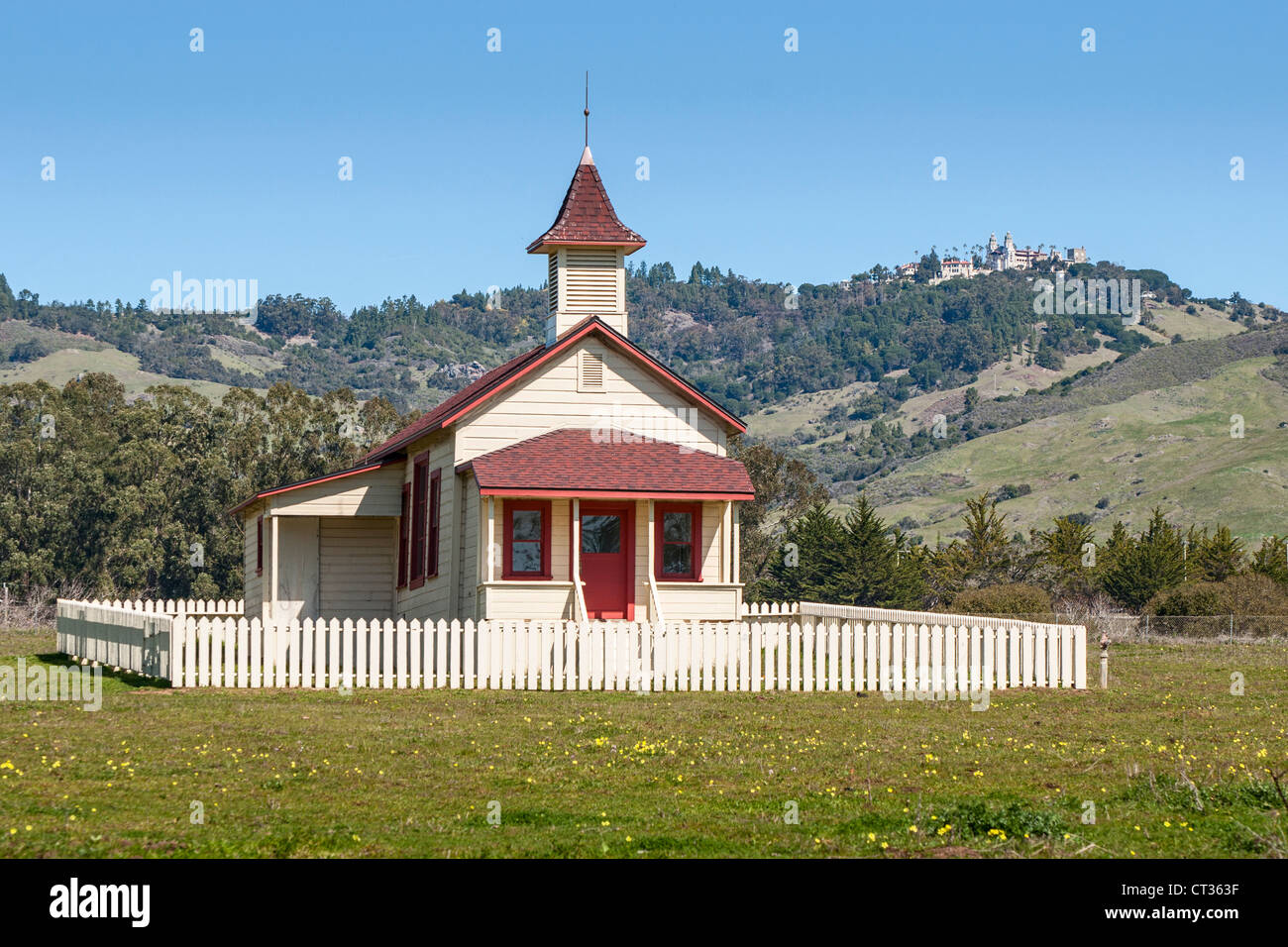 The Old San Simeon Schoolhouse in California with the famous Hearst Castle in the background. Stock Photo
