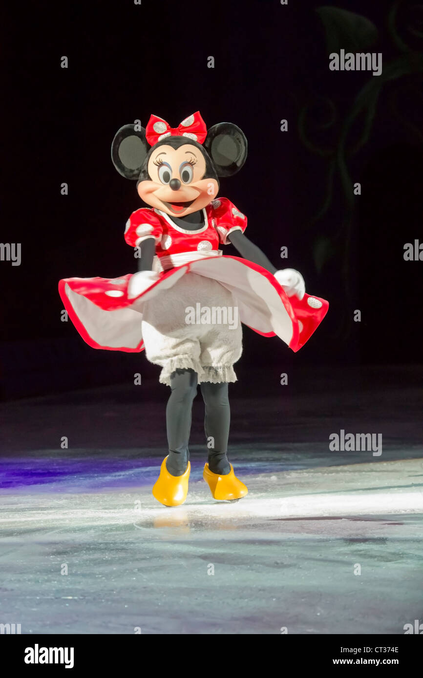 Minnie Mouse in a red or pink dress, yellow shoes and skates at the Disney on Ice Treasure Trove show Stock Photo