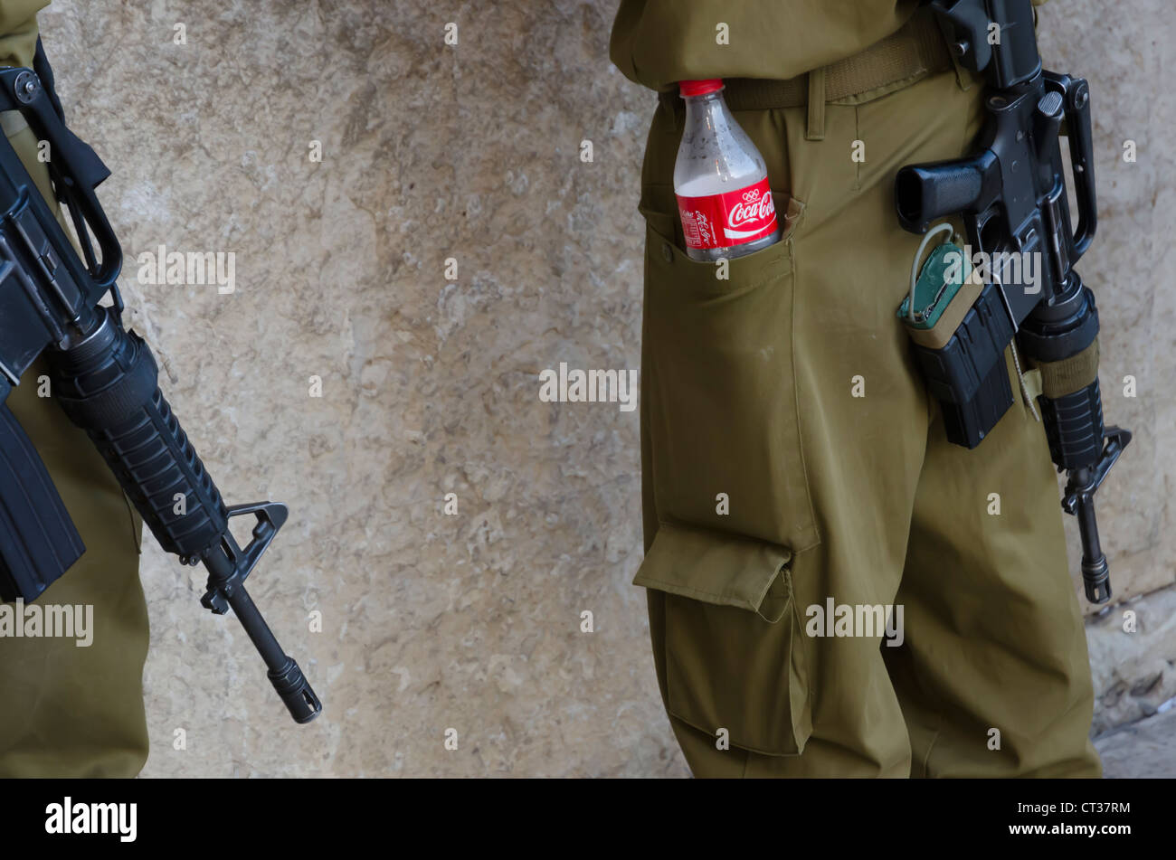 close up of a coca cola bottle in an israeli soldier's pockest with