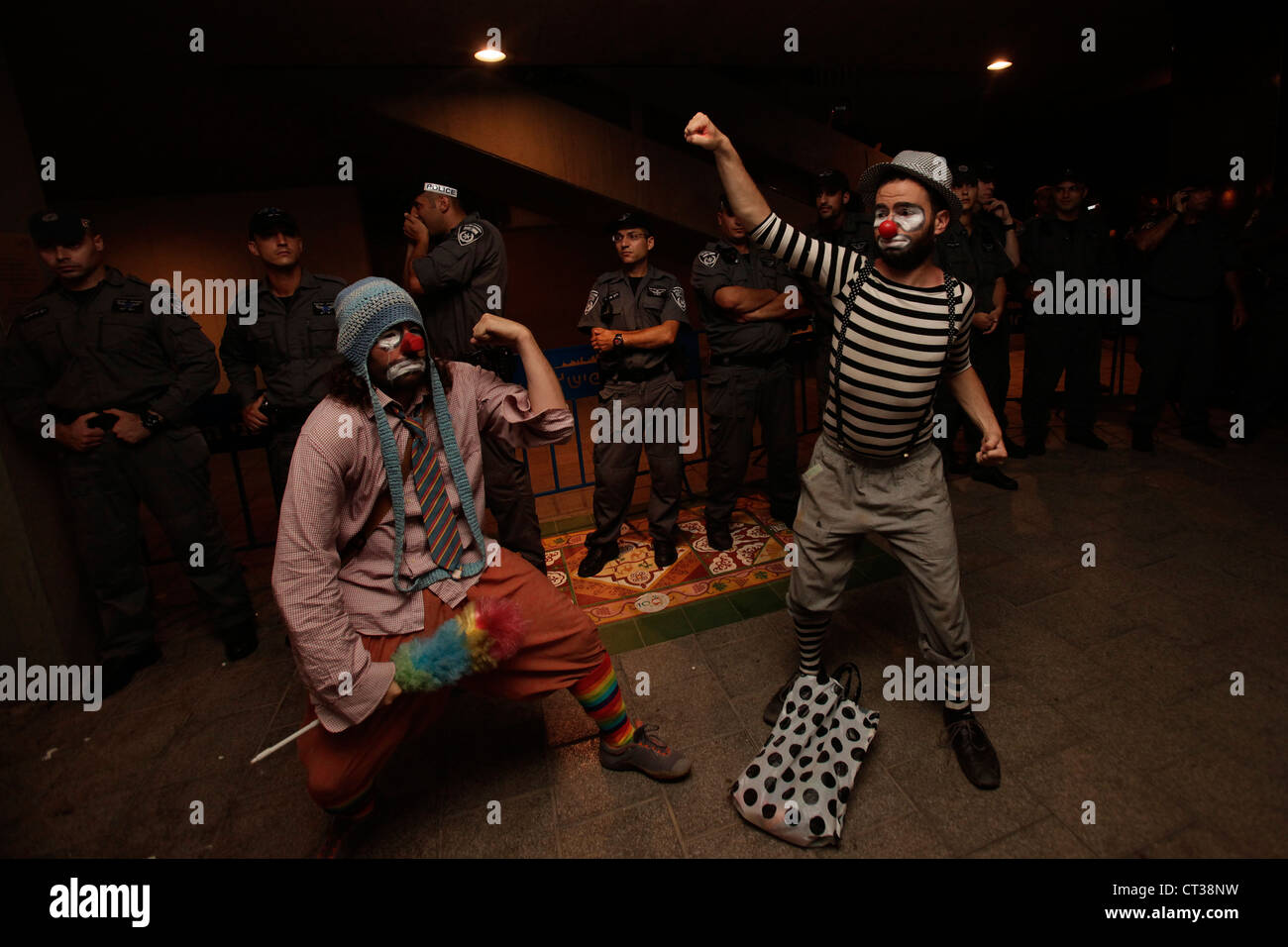 Israeli demonstrators dressed in clown outfit pose next to border policemen during Cost of Living protest  in Tel Aviv Israel. The social justice protest also named the Tents protest were a series of demonstrations in Israel beginning in July 2011 involving hundreds of thousands of protesters from a variety of socio-economic opposing the continuing rise in the cost of living particularly housing. Stock Photo