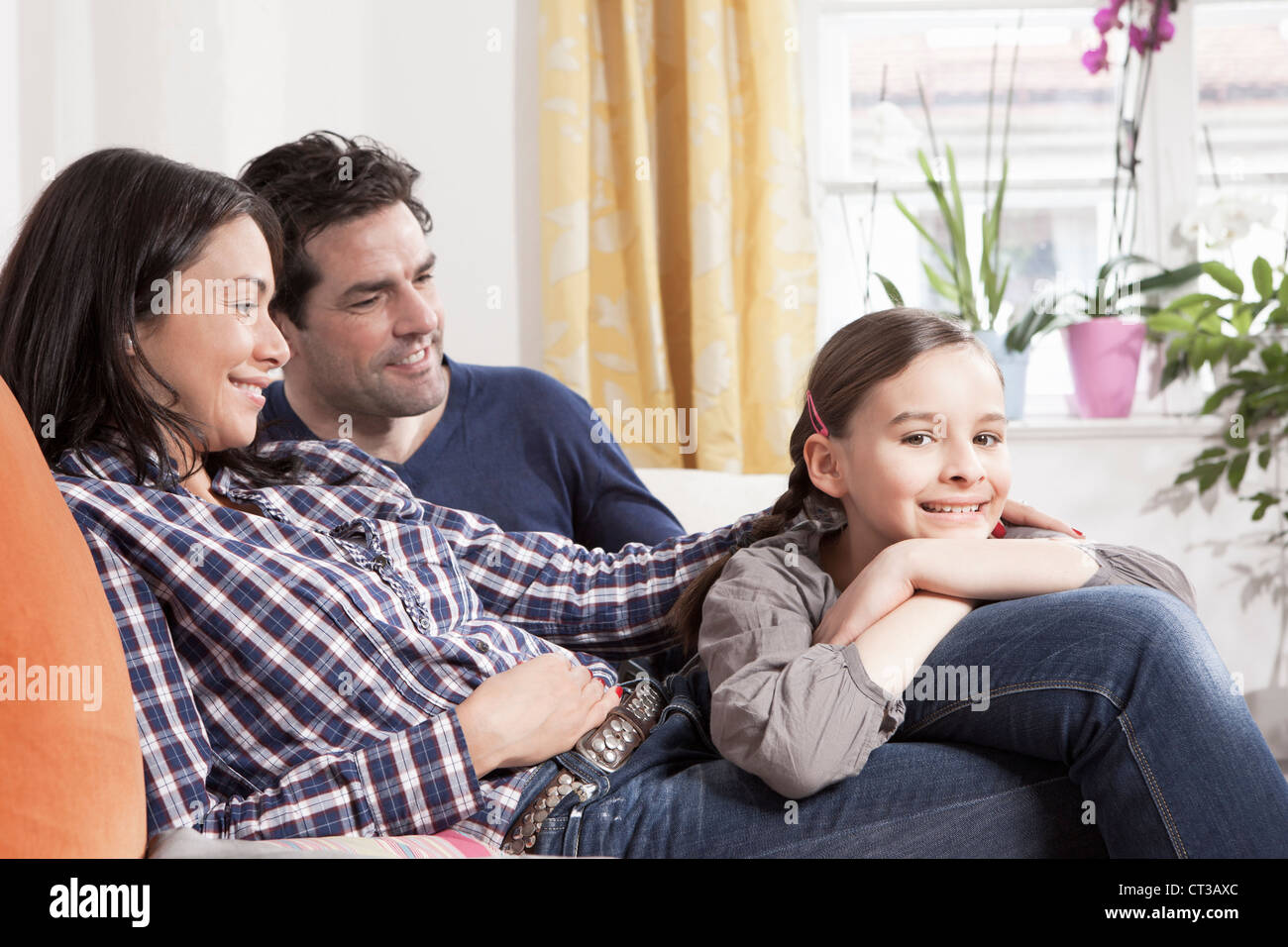 Family relaxing on sofa in living room Stock Photo Alamy