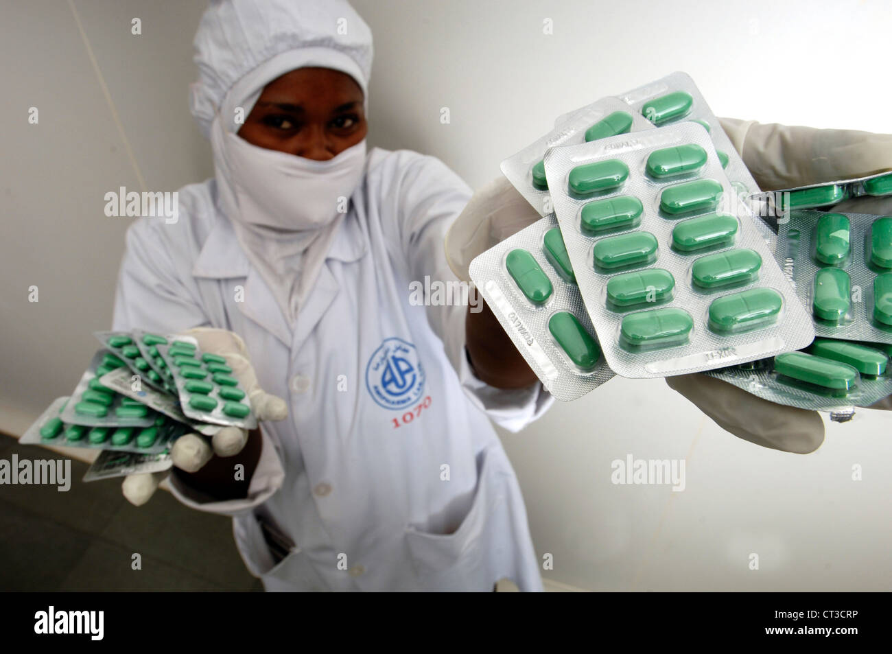 A technician holding a selection of green tablets in blister packs. Stock Photo