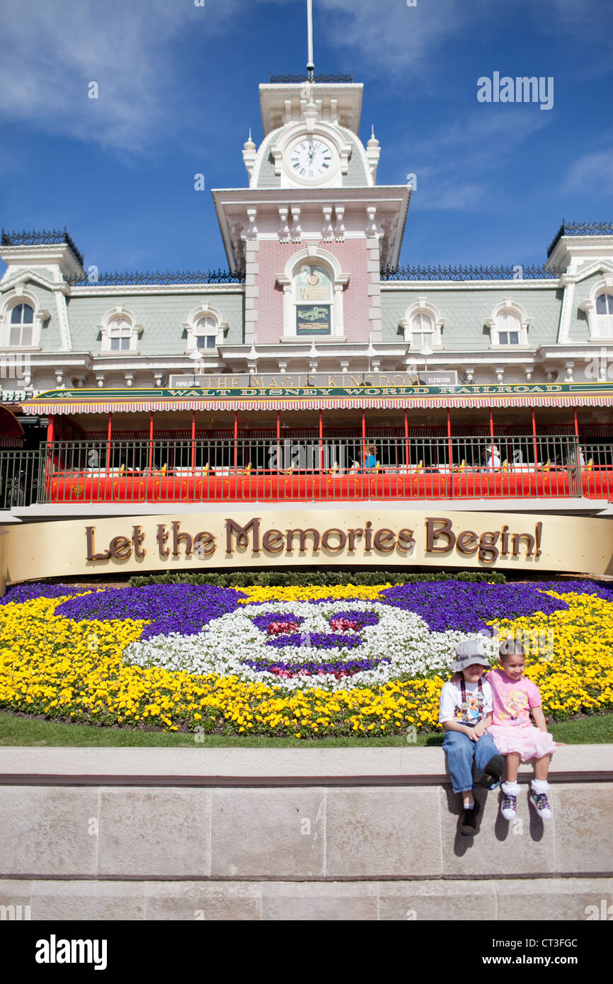Two girls posing at the entrance of Magic Kingdom with the 'Let your memories begin' sign, Disney World, Orlando, Florida Stock Photo