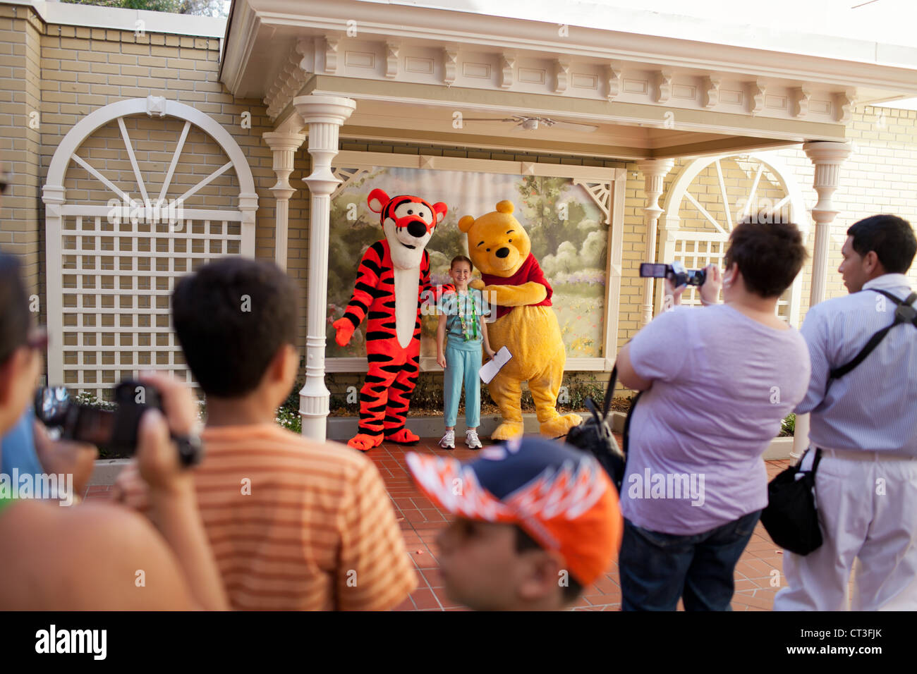 A girl being photographed with Tiger and Winnie the Poo in Magic Kingdom, Disney World, Orlando, Florida Stock Photo