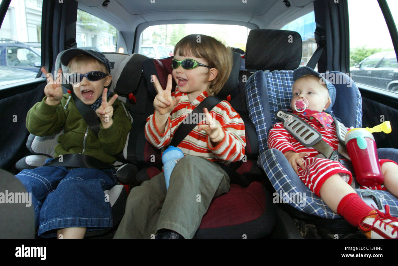 Berlin, three children strapped in their child seats Stock Photo Alamy