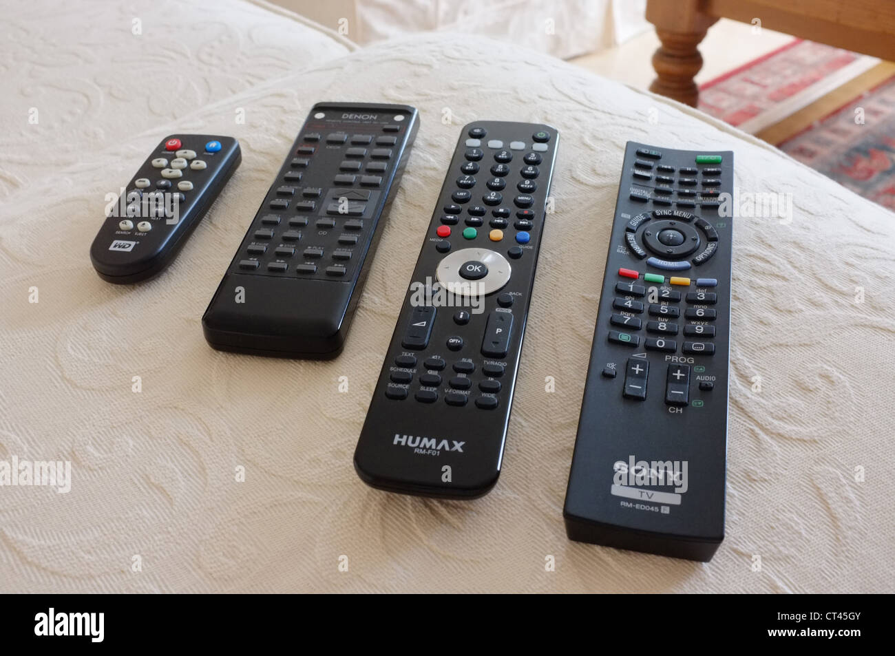 Four television remote controls Stock Photo