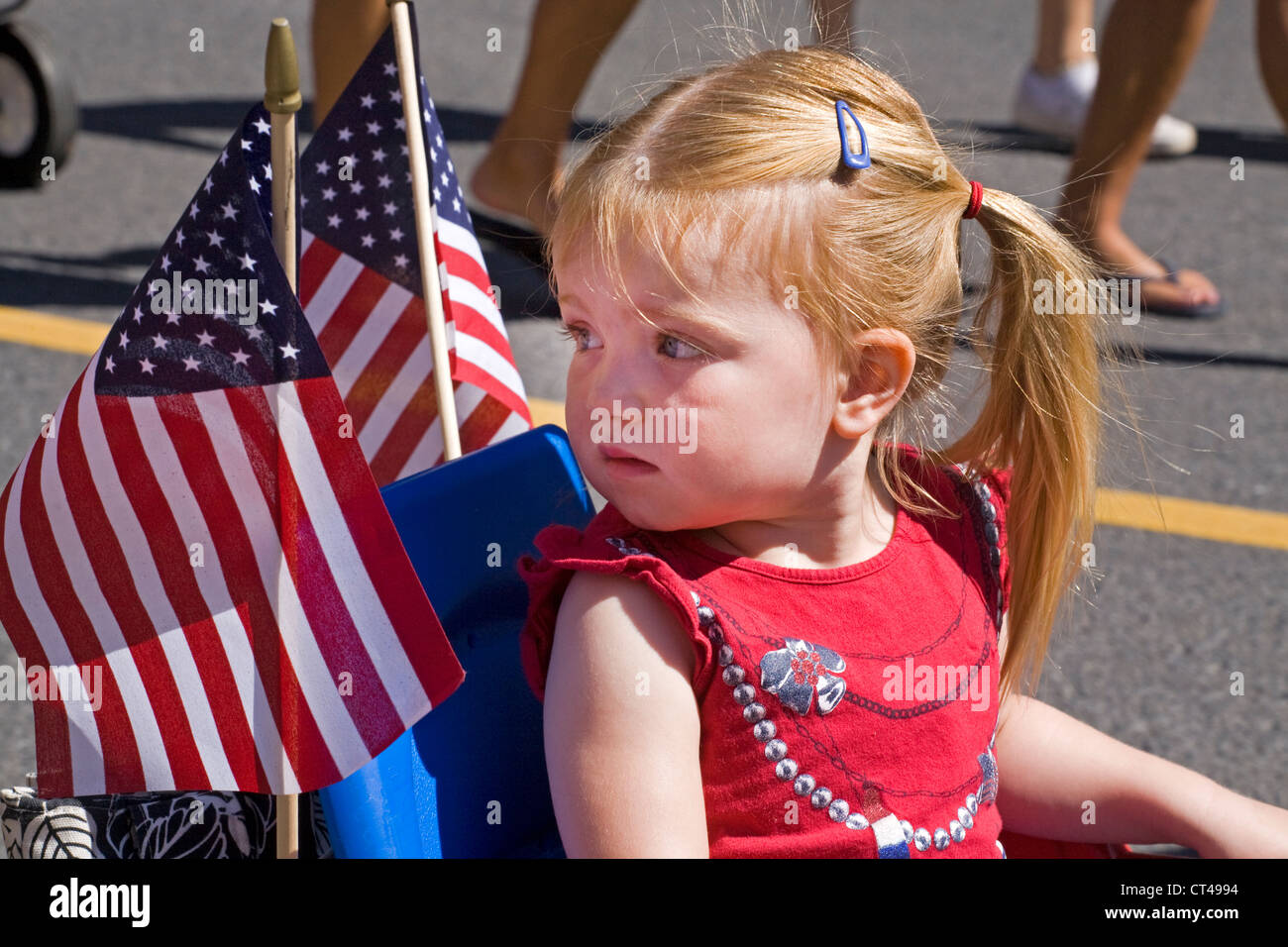 A little girl with american flags at a 4th of july parade Stock Photo