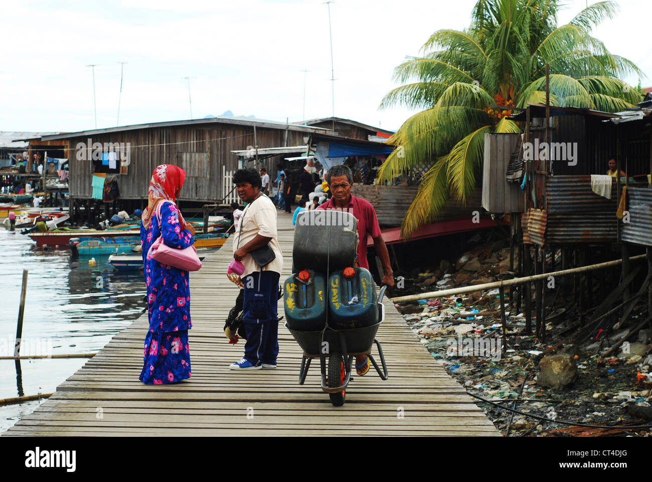 Malaysia, Borneo, Semporna, women walking with chicken in hand Stock Photo