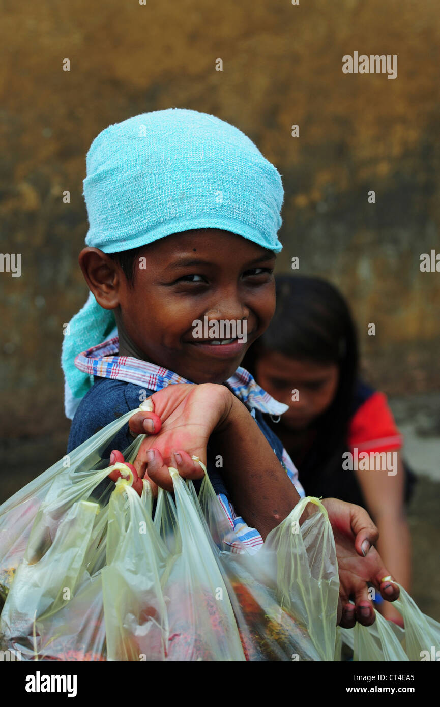 Malaysia, Borneo, Semporna, young boy with plastic bag of fruit in hand Stock Photo