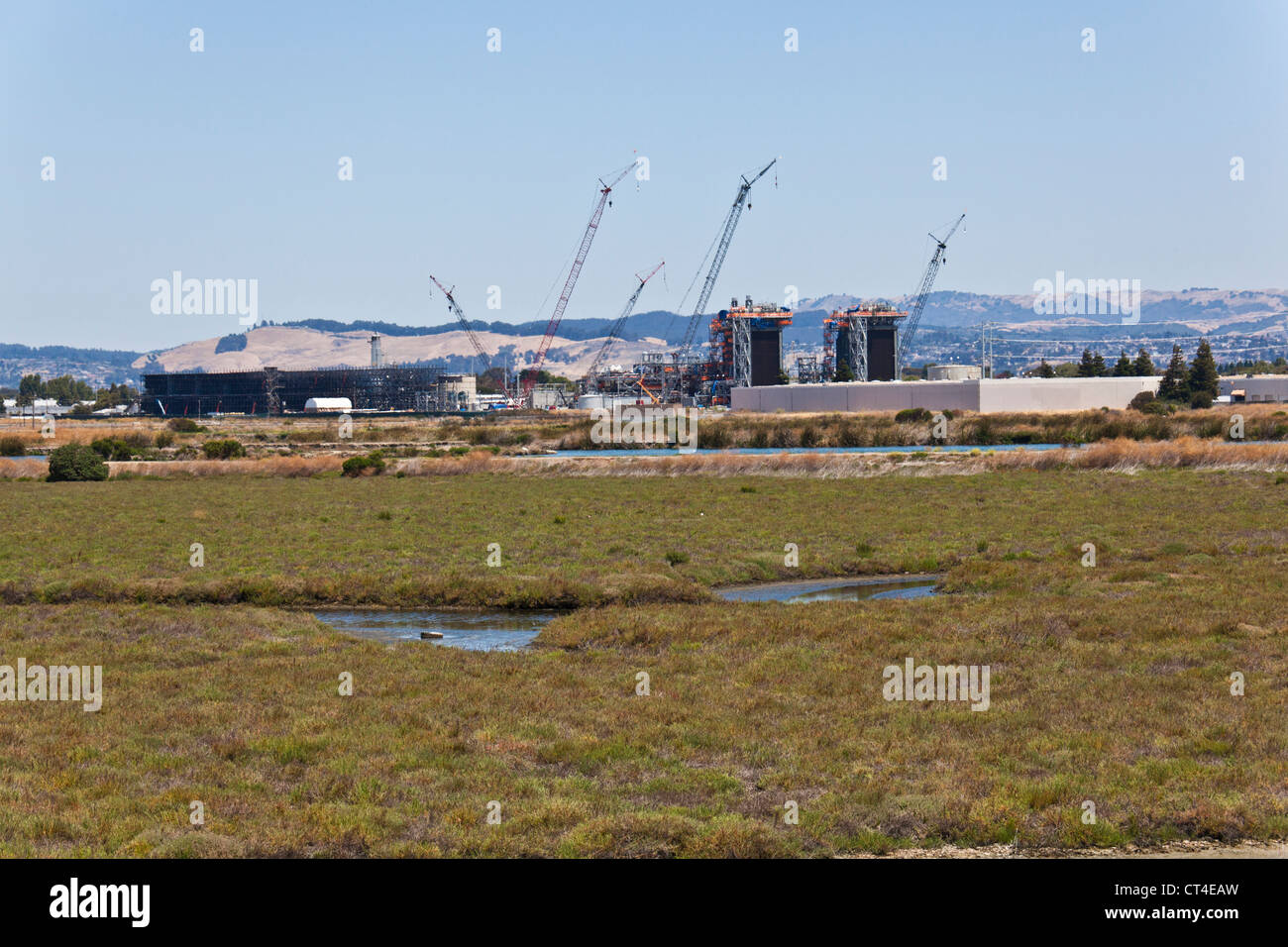 A natural gas fired power plant is under construction near marshes and wetlands along San Francisco Bay. Stock Photo