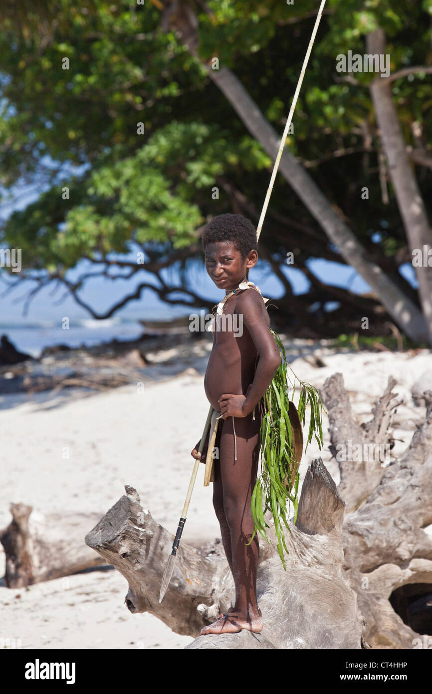 Indonesia, Papua New Guinea, Nuana Island. Young boy in traditional dress  fishing on beach Stock Photo - Alamy