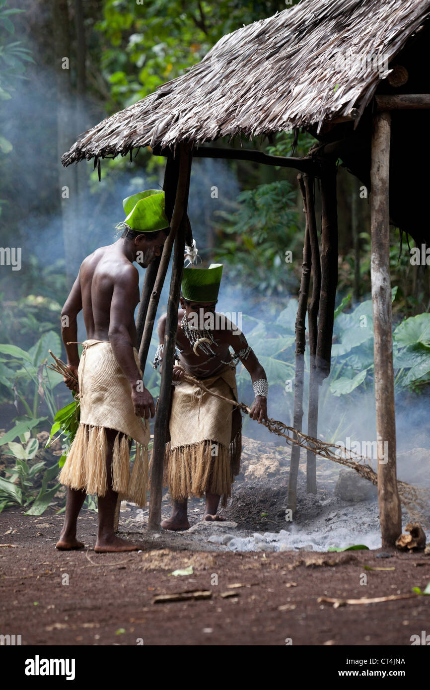 South Pacific, Vanuatu, Port Vili, Ekasup Village. Two warriors raking ash before hot coal ceremony performance for tourists. Stock Photo