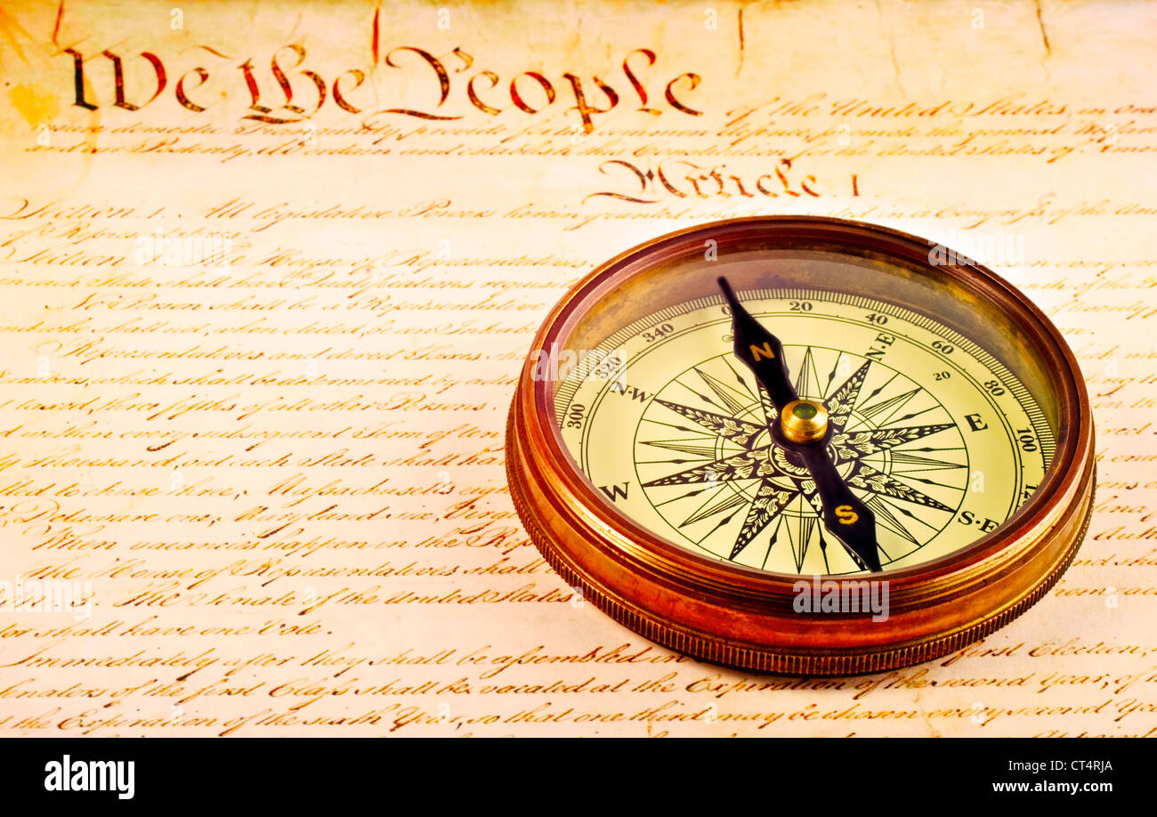 Antique compass and first words of American Constitution. Concepts of direction and unity. Stock Photo