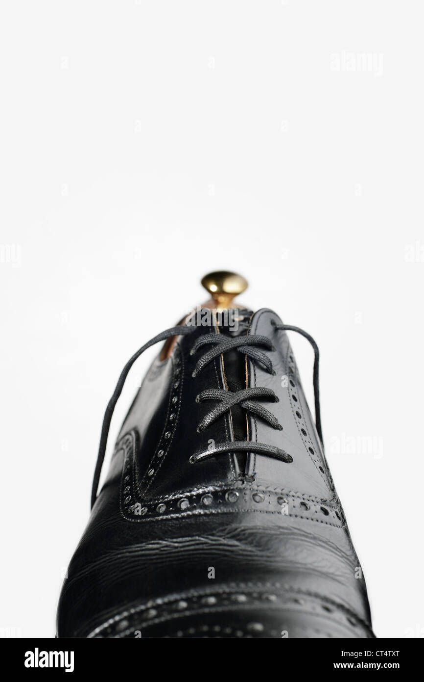 Black men's shoe with golden shoetree Stock Photo