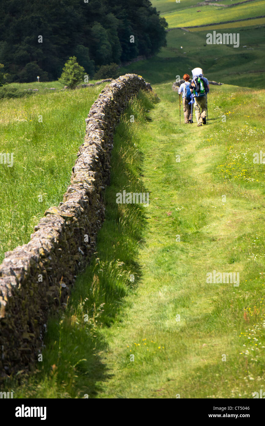 Two hikers walking the route alongside Hadrians Wall. While the wall has long since gone, you can see the Vallum (v shape ditch) Stock Photo