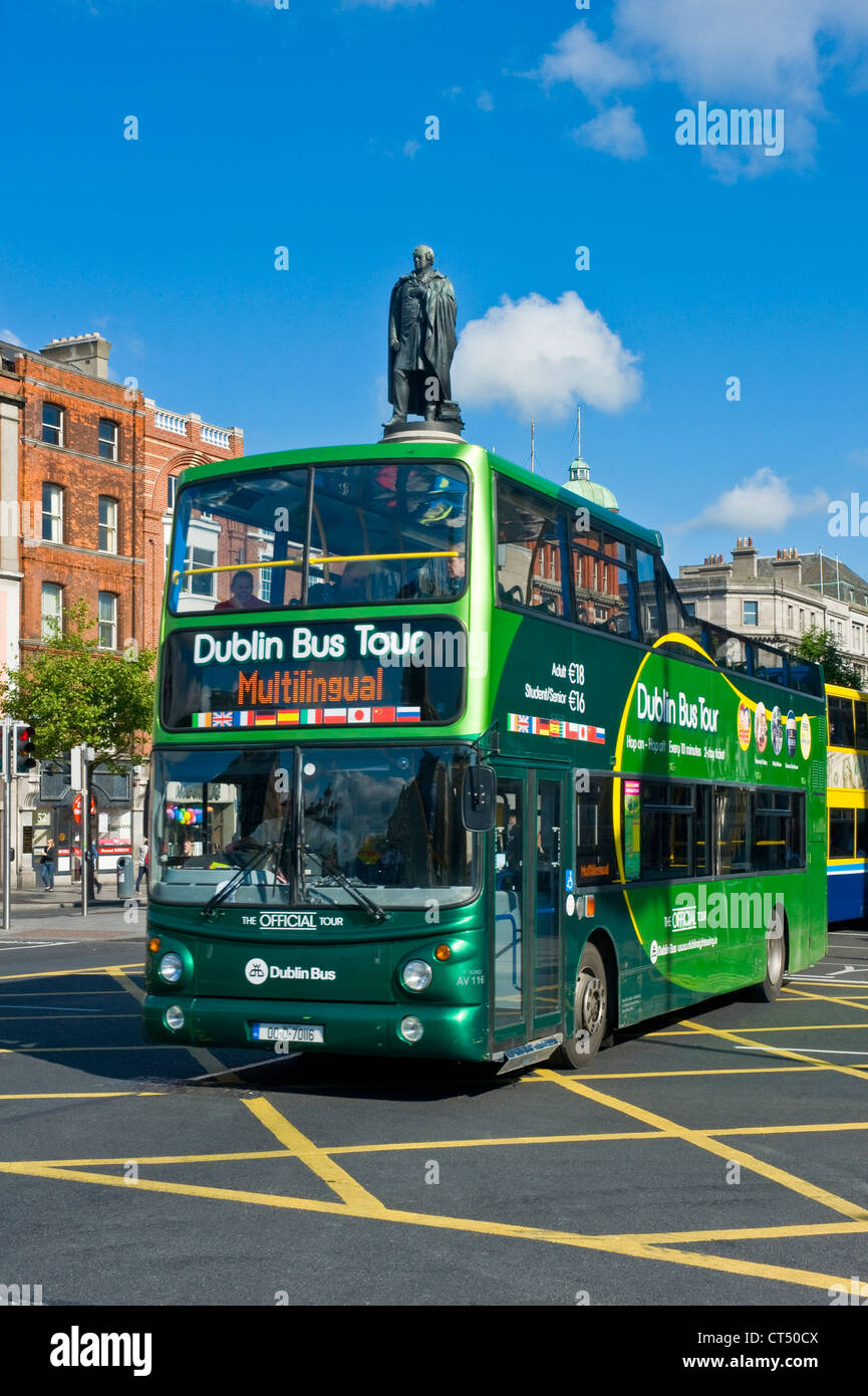 The O'Connell monument in O'Connell street in the center of Dublin with a 'hop on hop off' tour bus driving past. Stock Photo