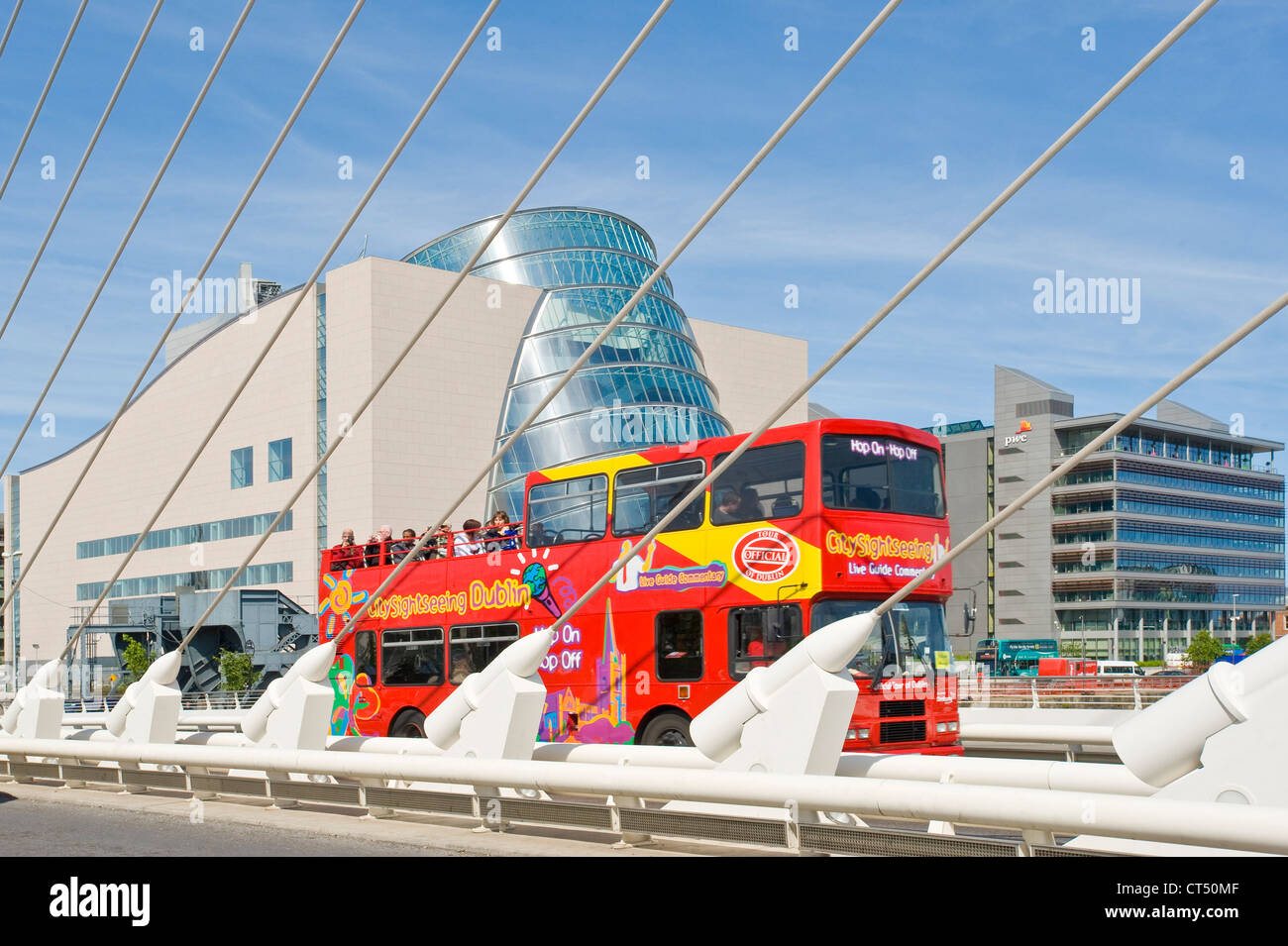 The Samual Beckett Bridge with a Dublin city 'hop on hop off' tour bus driving across. Stock Photo