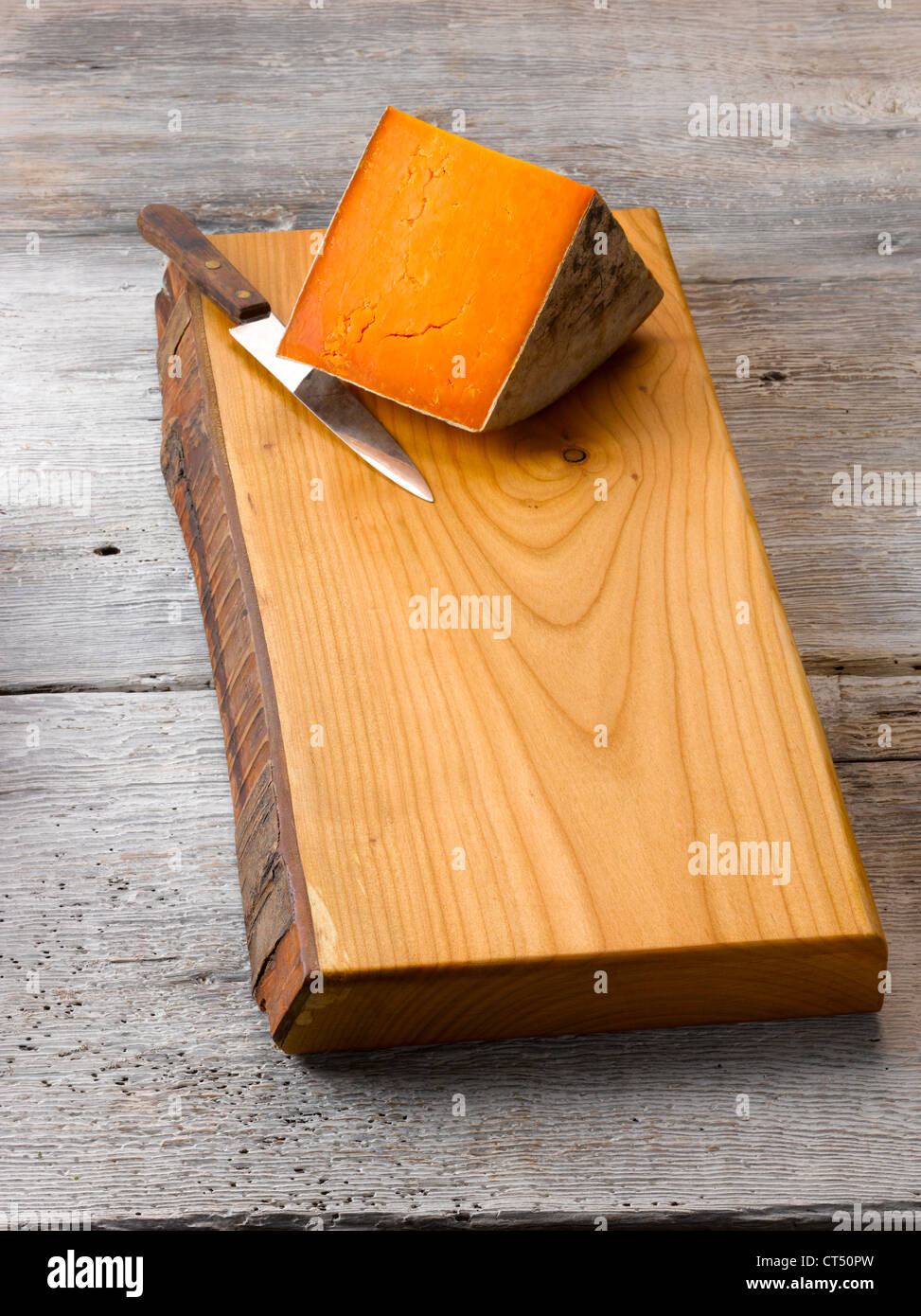 Rustic wood chopping board with cheese Stock Photo