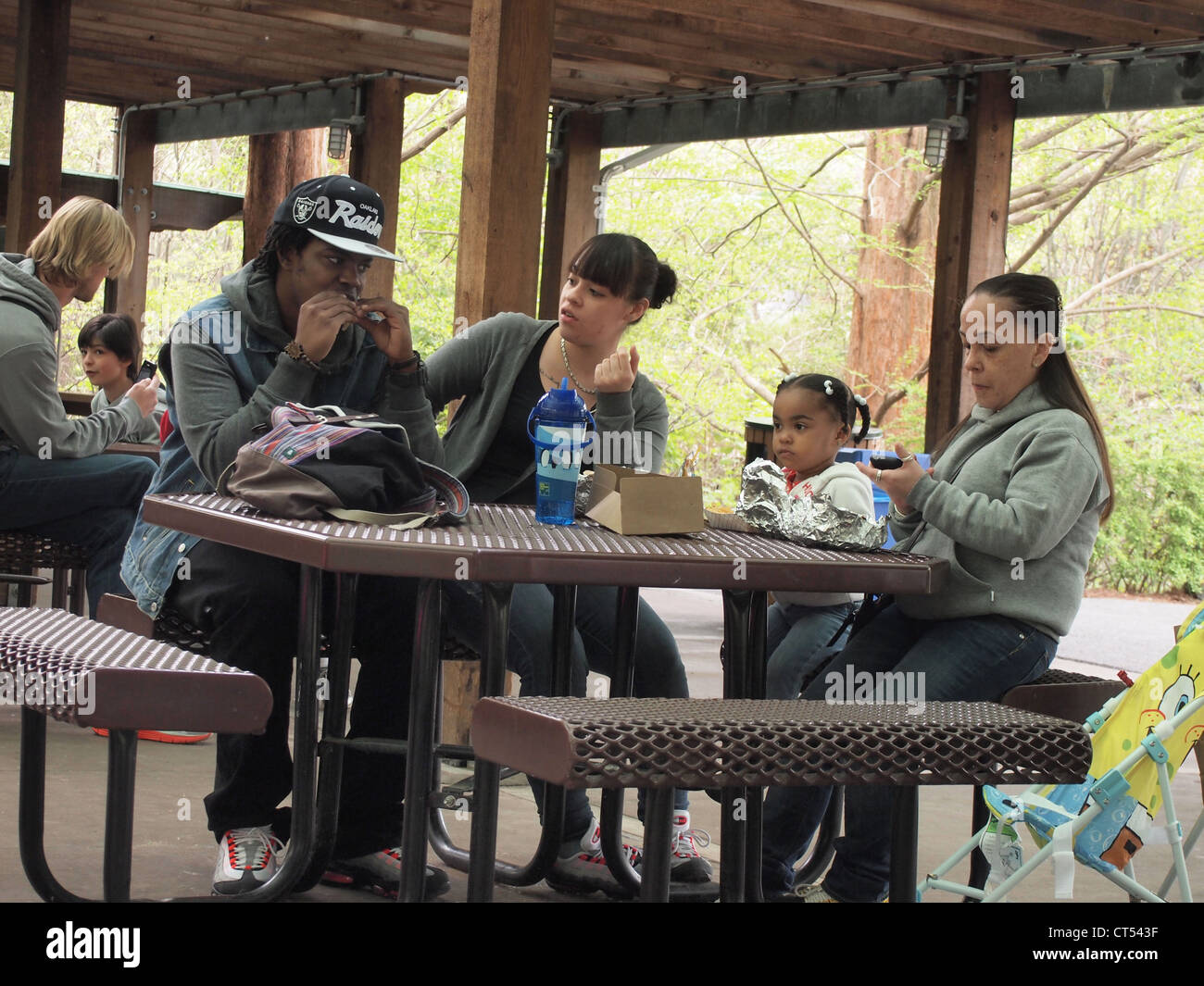 Family eating lunch at a picnic table at the Bronx Zoo, Bronx, New York