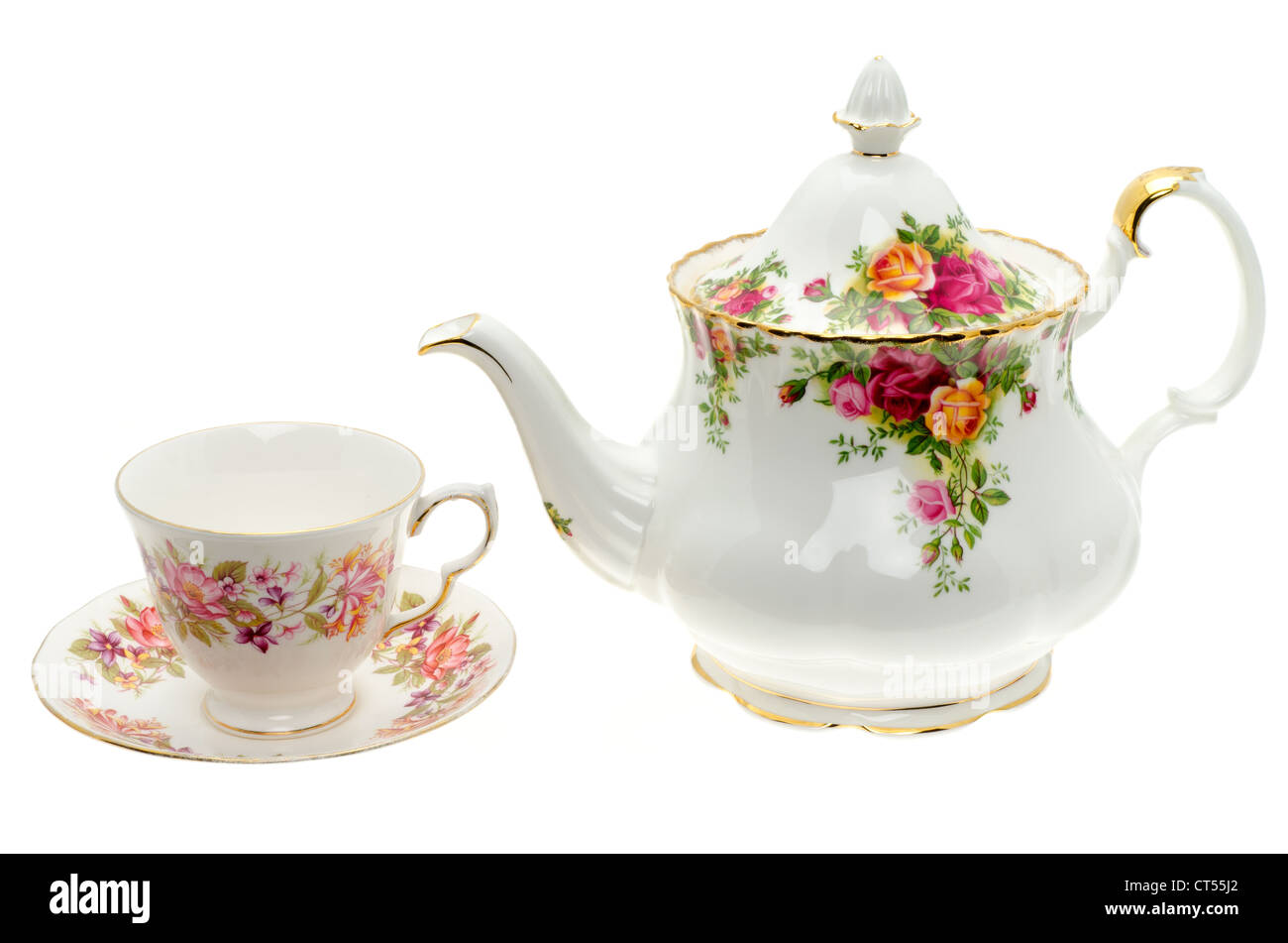 Vintage bone China teapot and a cup and saucer - studio shot with a white background Stock Photo