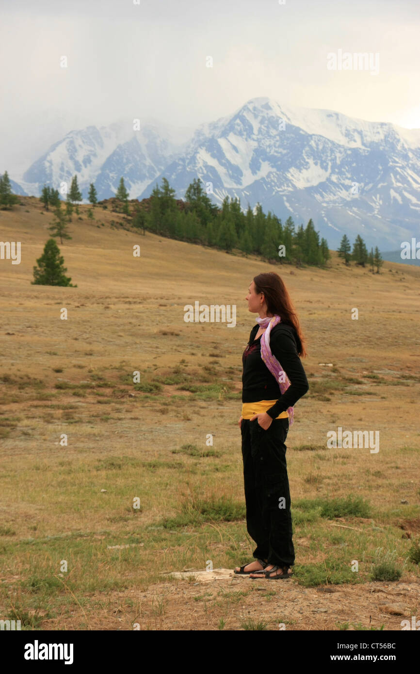 Woman admiring snowcapped mountains, Altai, Siberia, Russia Stock Photo