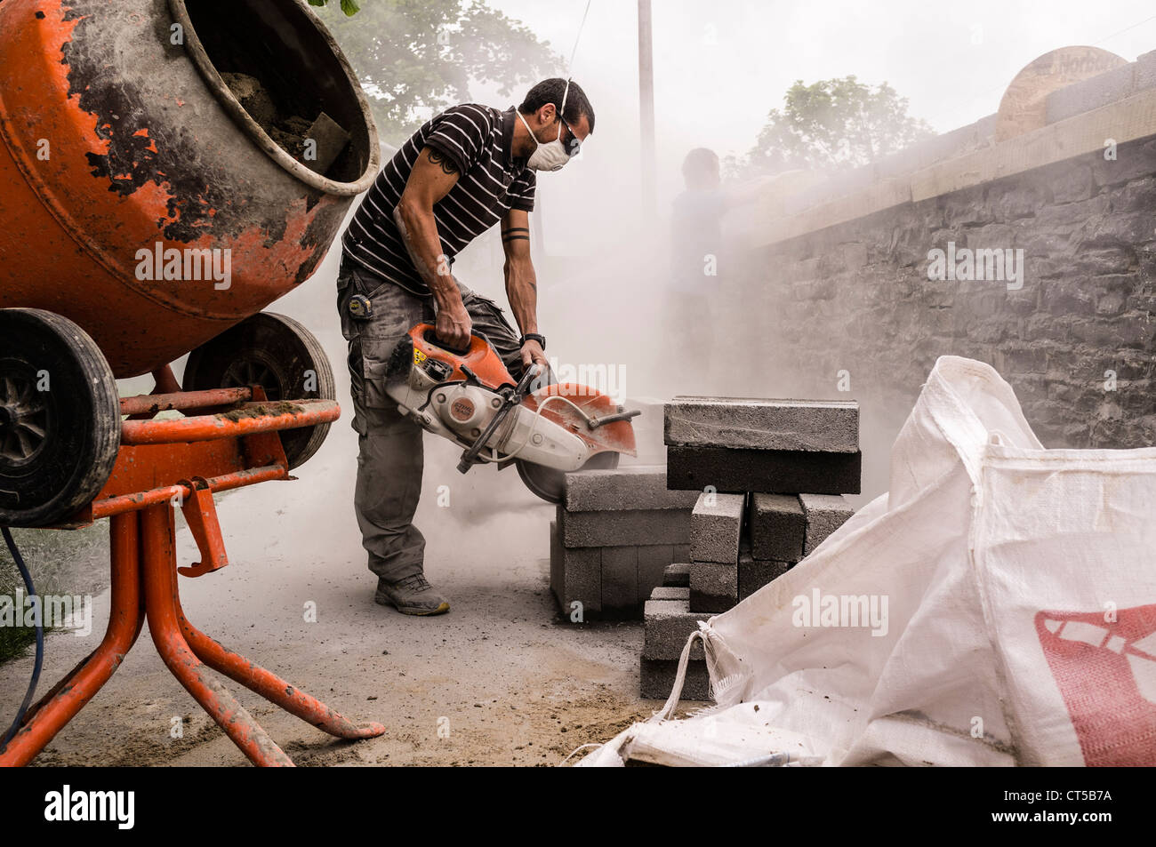 A workman using an angle grinder power tool to cut a concrete block, UK  Stock Photo - Alamy