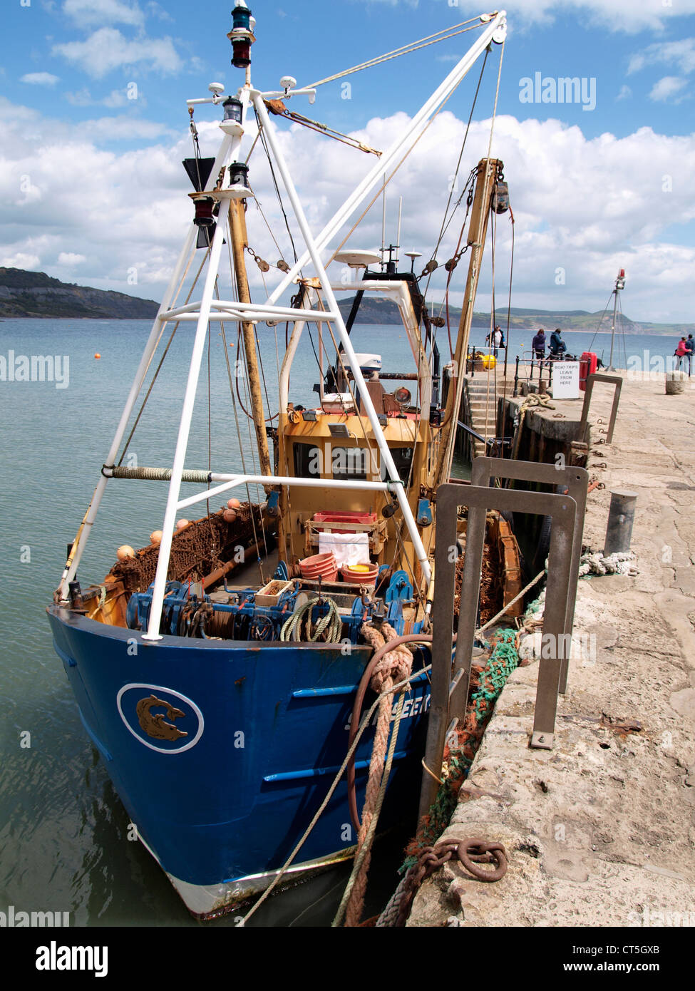 Commercial fishing boat moored against the harbour wall, Lyme Regis