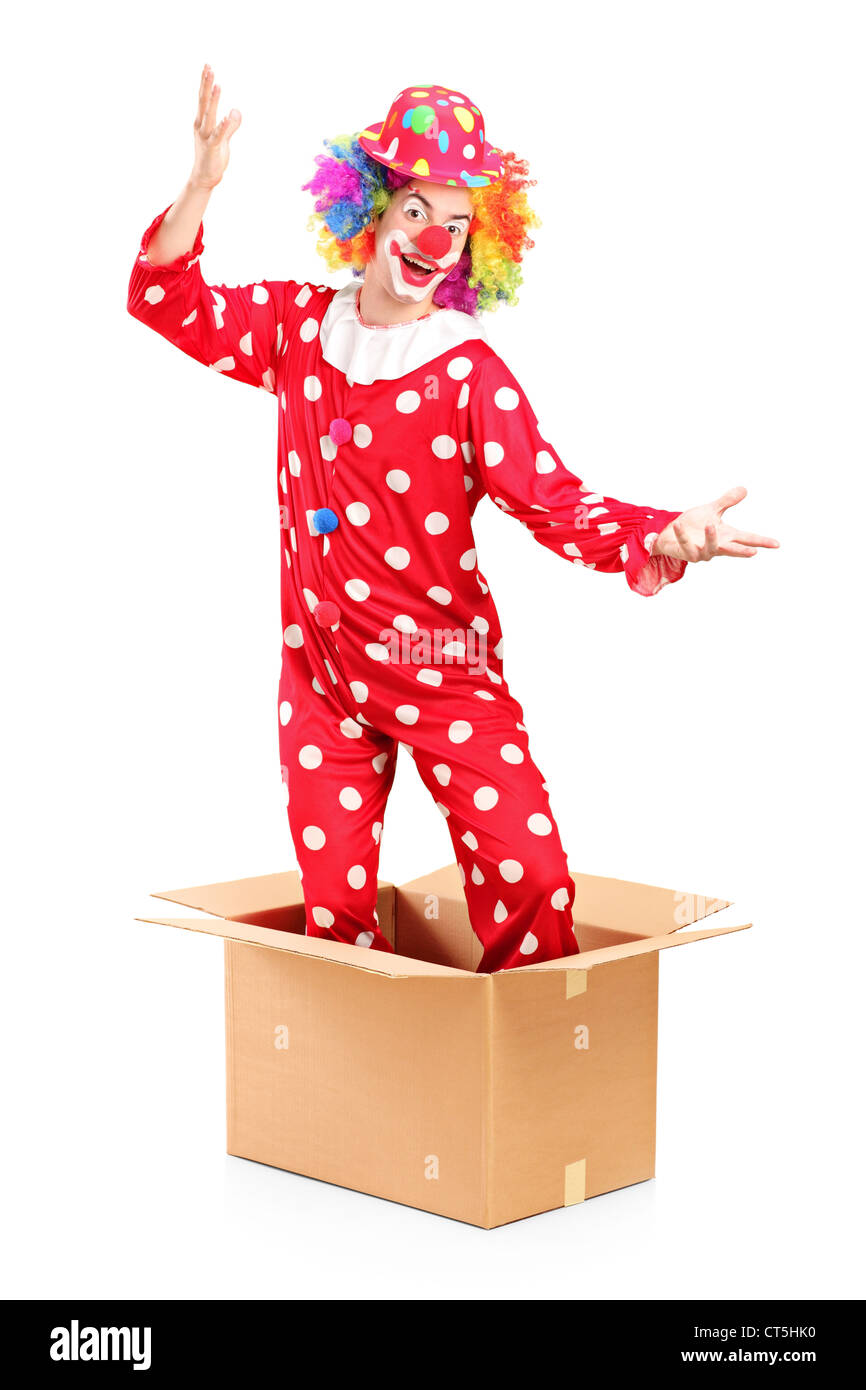 A smiling clown coming out of a cardboard box isolated on white background Stock Photo