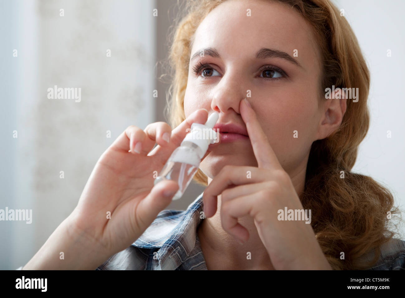 WOMAN USING NOSE SPRAY Stock Photo Alamy