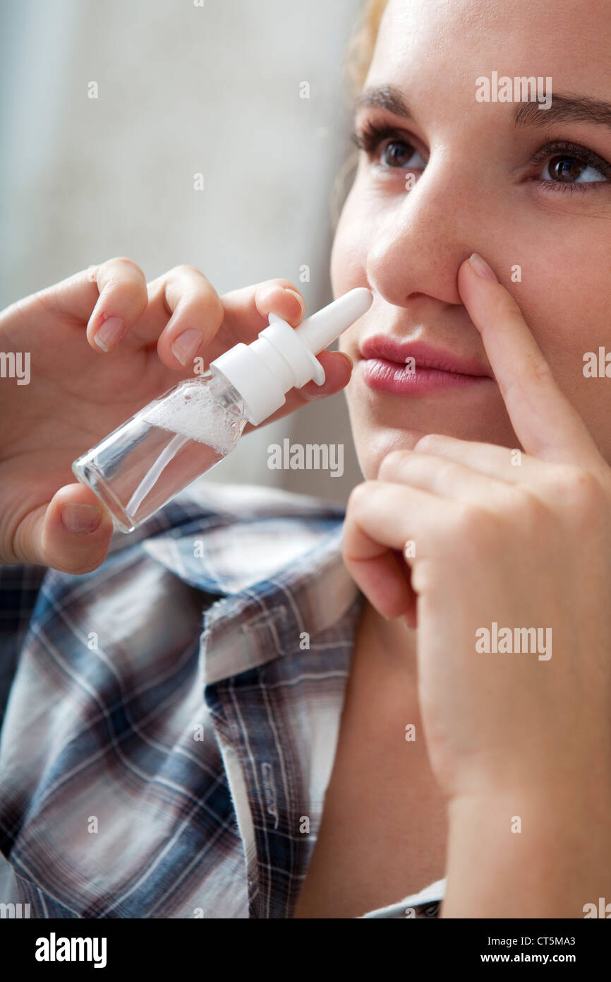 WOMAN USING NOSE SPRAY Stock Photo Alamy