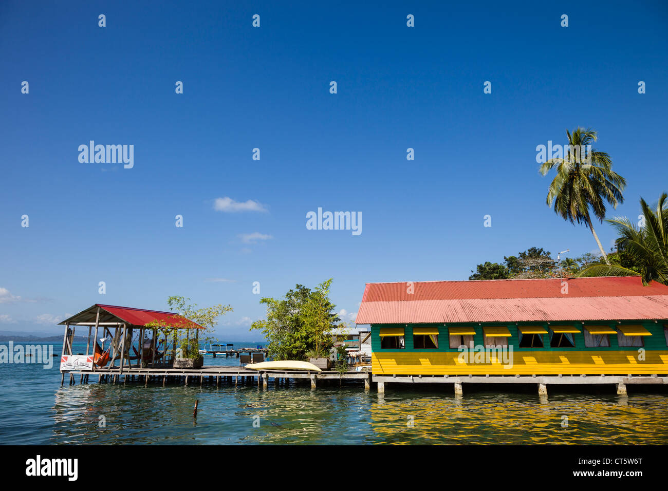 Brightly colored wooden houses sit over the sea in the historic town of Old Bank on Isla Bastimentos, Bocas del Toro, Panama. Stock Photo