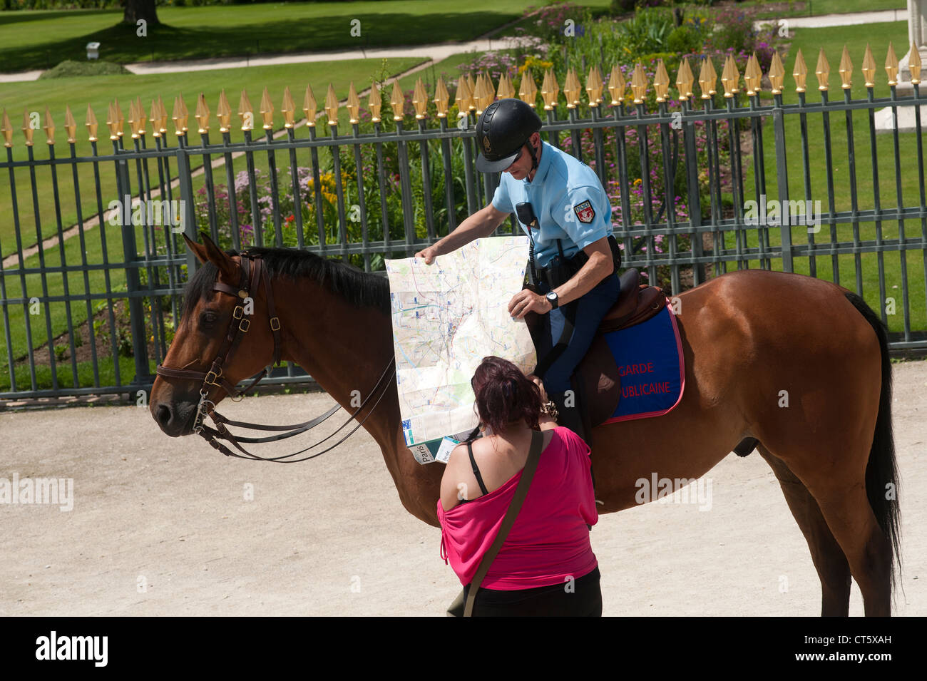 Paris, France - A policeman on horse giving informations to a tourist. Stock Photo