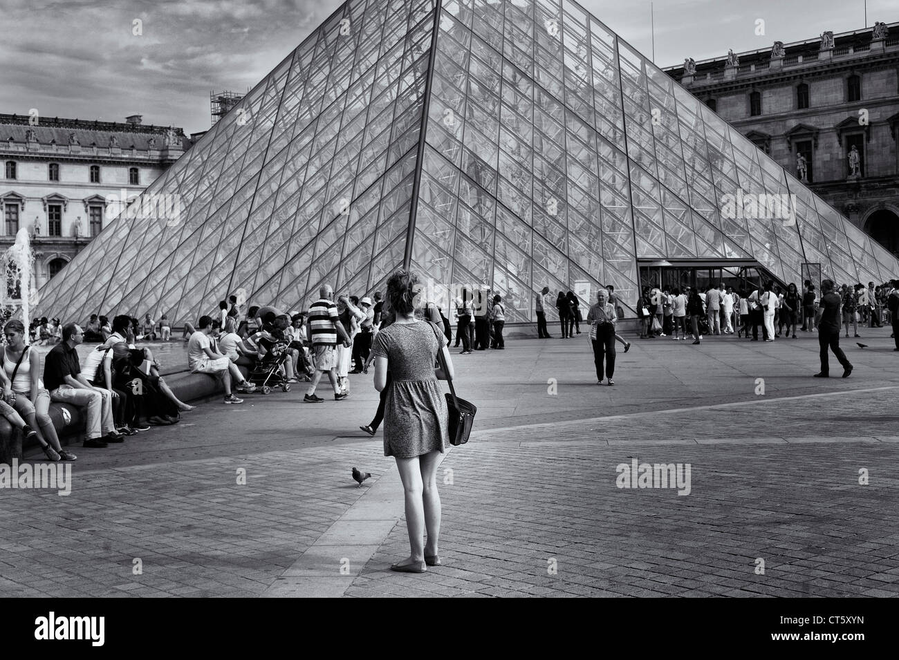 Paris - Woman standing  in front of Louvre museum Stock Photo