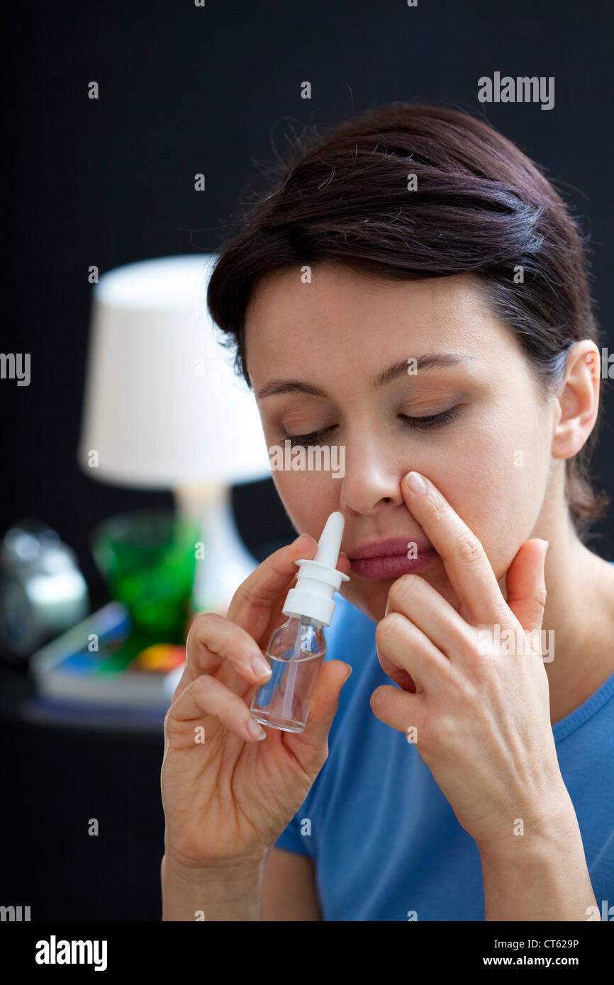 WOMAN USING NOSE SPRAY Stock Photo Alamy