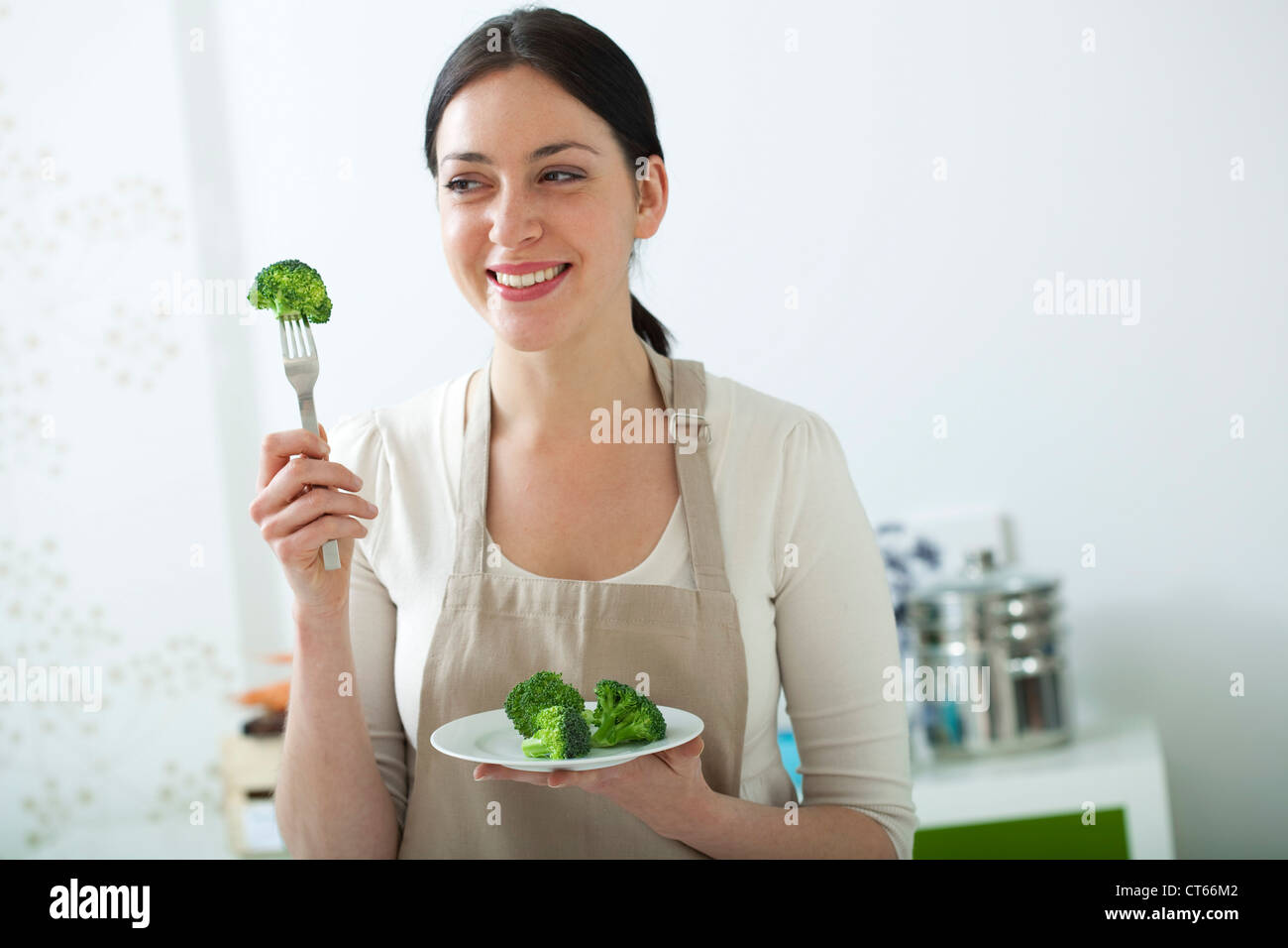 Ем капусту вечером. Девушка ест брокколи. Женщина ест. Женщина ест овощи. Человек ест овощи.