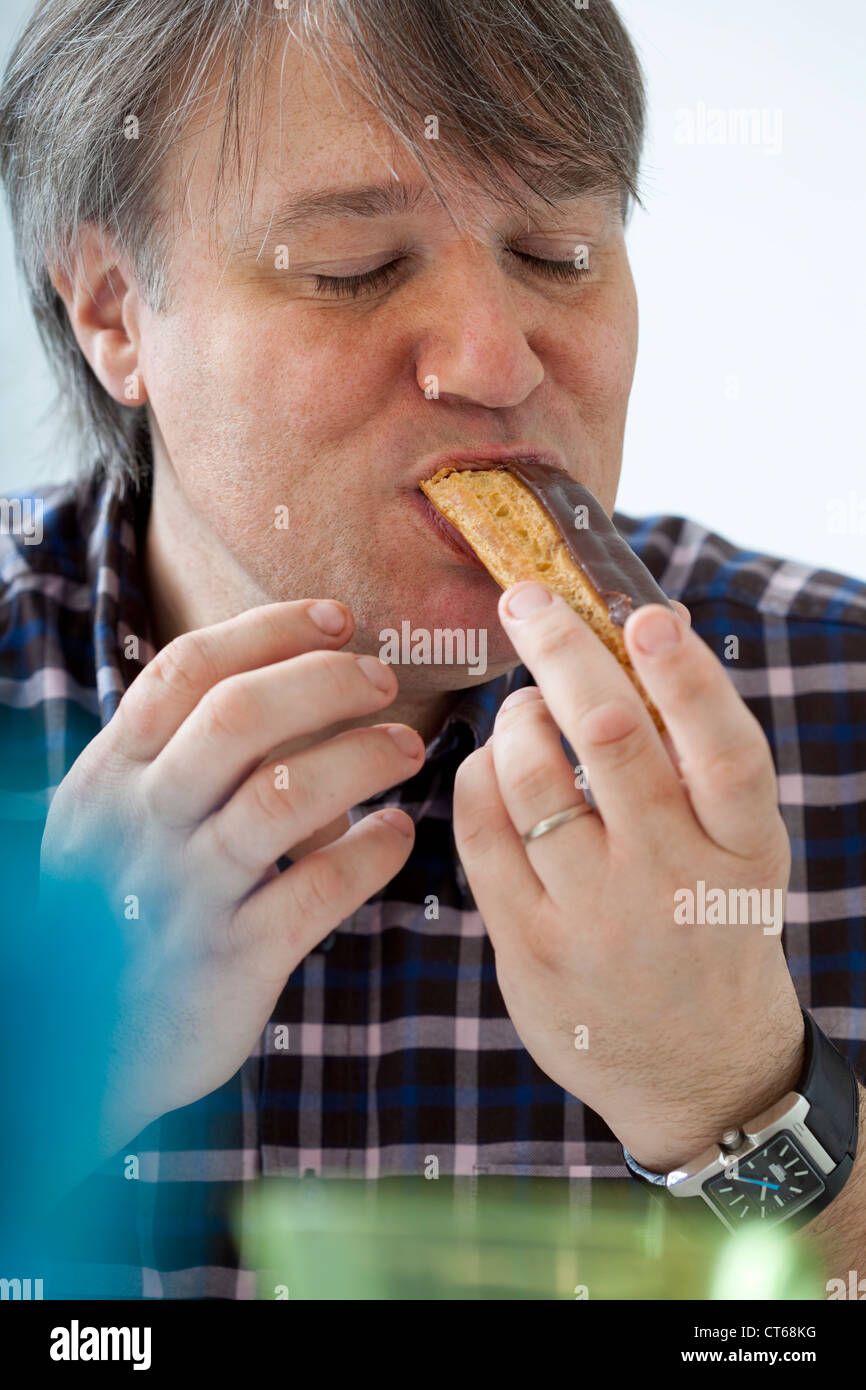 MAN EATING SWEETS Stock Photo