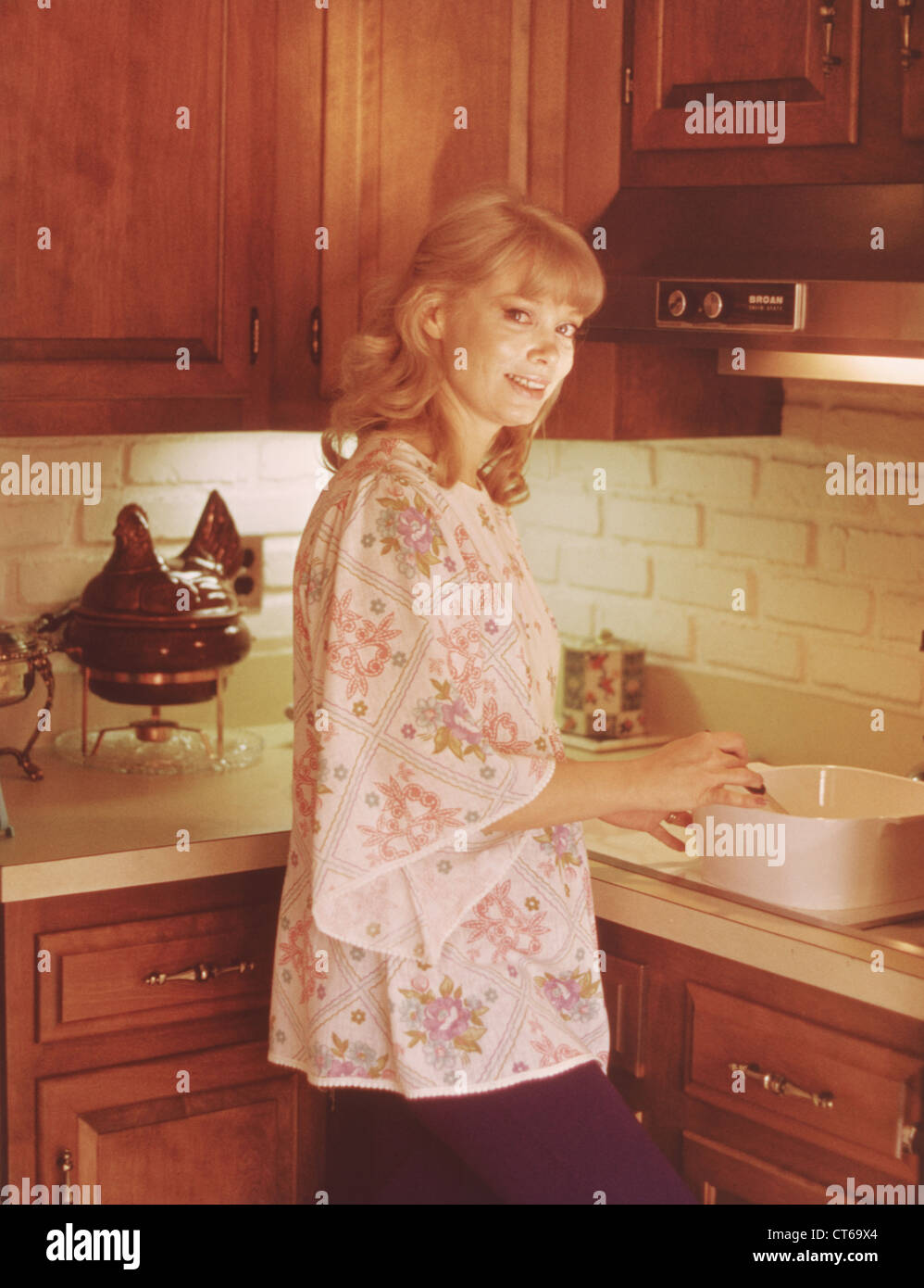 Woman preparing food in kitchen of 1970's home Stock Photo