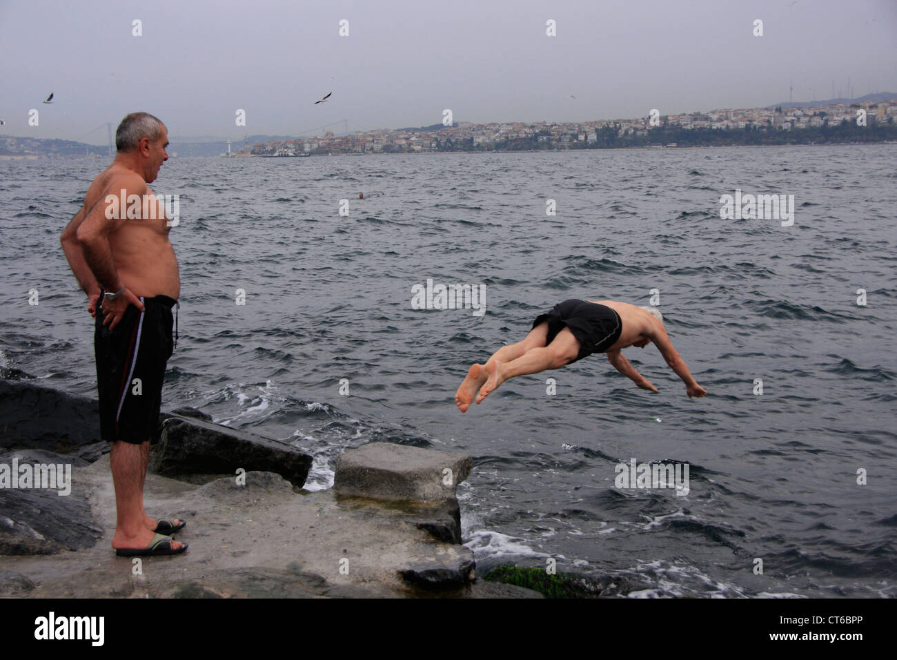 Turkish man diving into Bosphorus strait, Istanbul, Turkey Stock Photo