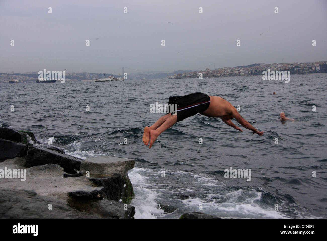 Turkish man diving into Bosphorus strait, Istanbul, Turkey Stock Photo