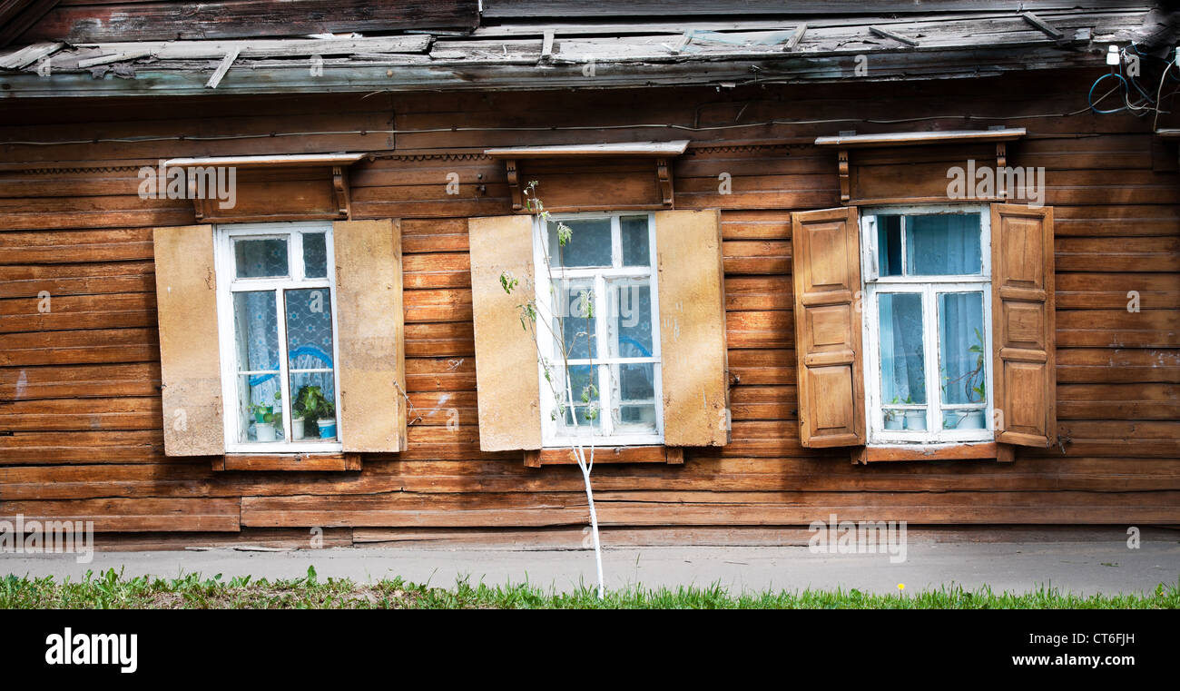 Old traditional wooden house with three open windows. Kostroma, golden ...