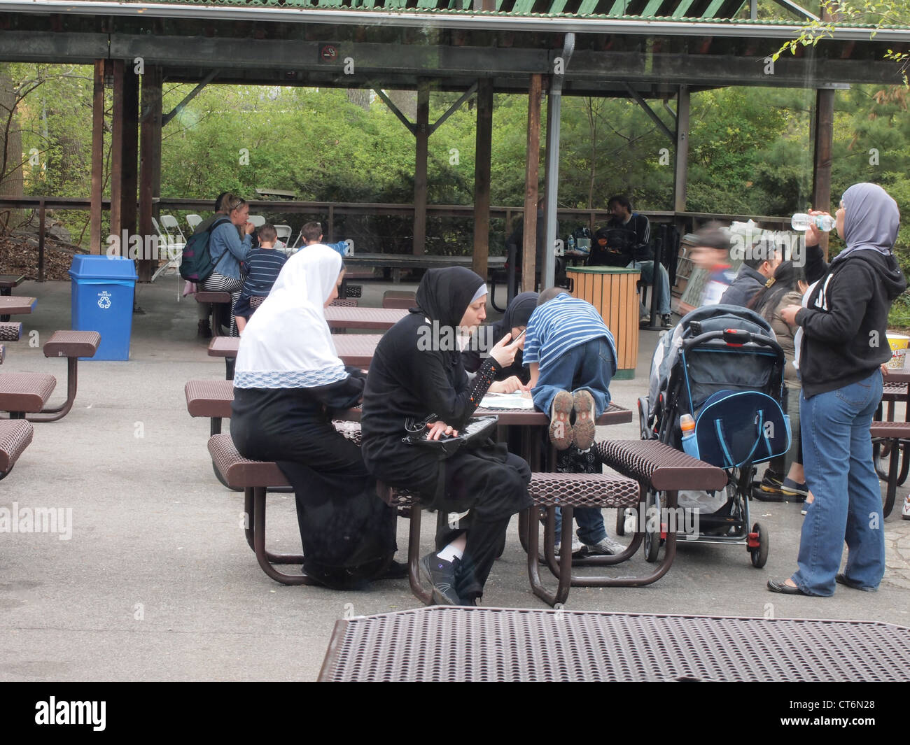 Muslim women and children at a picnic table at the Bronx Zoo, Bronx, New York, USA, April 18, 2012, © Katharine Andriotis Stock Photo