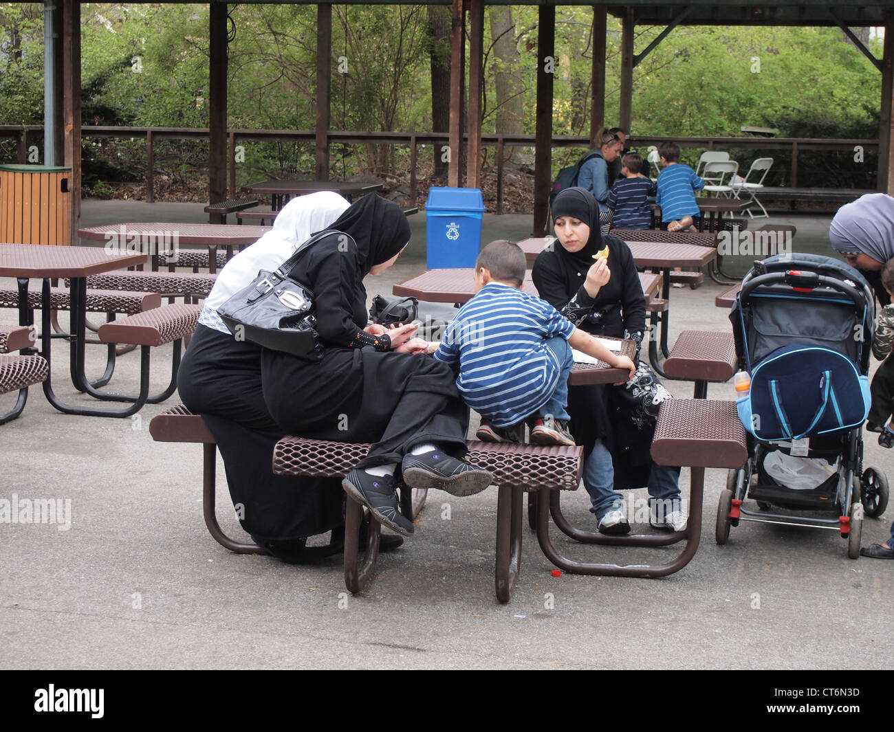 Muslim women and children at a picnic table at the Bronx Zoo, Bronx, New York, USA, April 18, 2012, © Katharine Andriotis Stock Photo