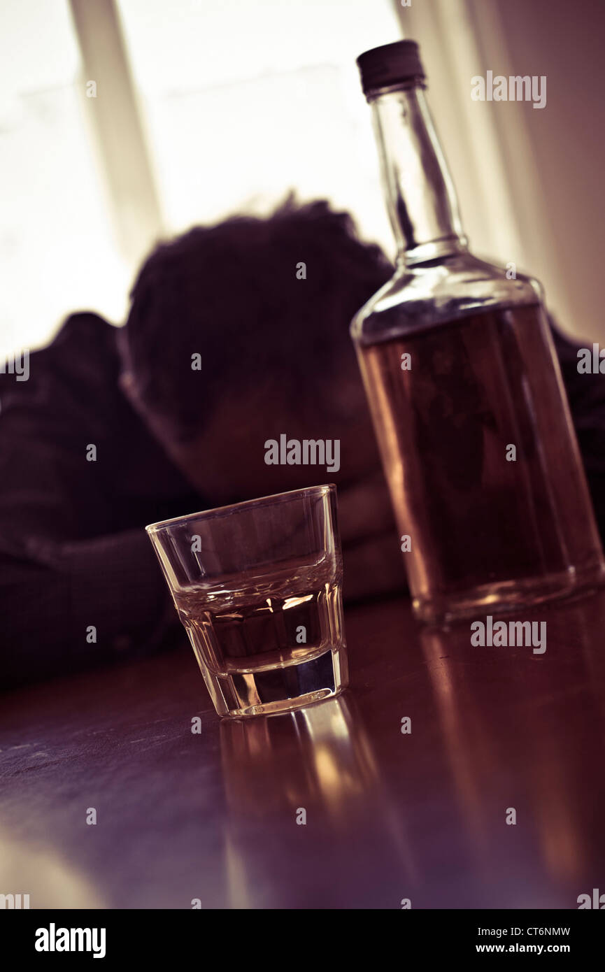 drunk man with a bottle and glass of whiskey Stock Photo