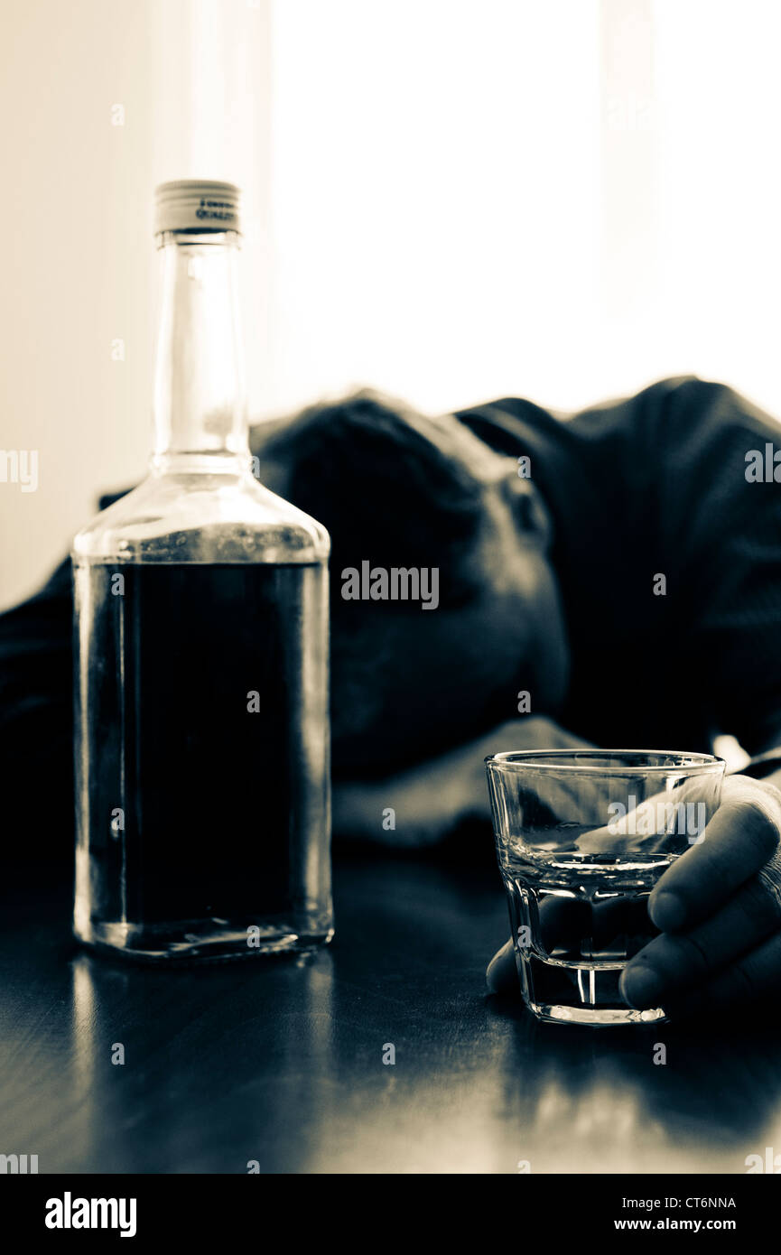 drunk man with a bottle and glass of whiskey Stock Photo