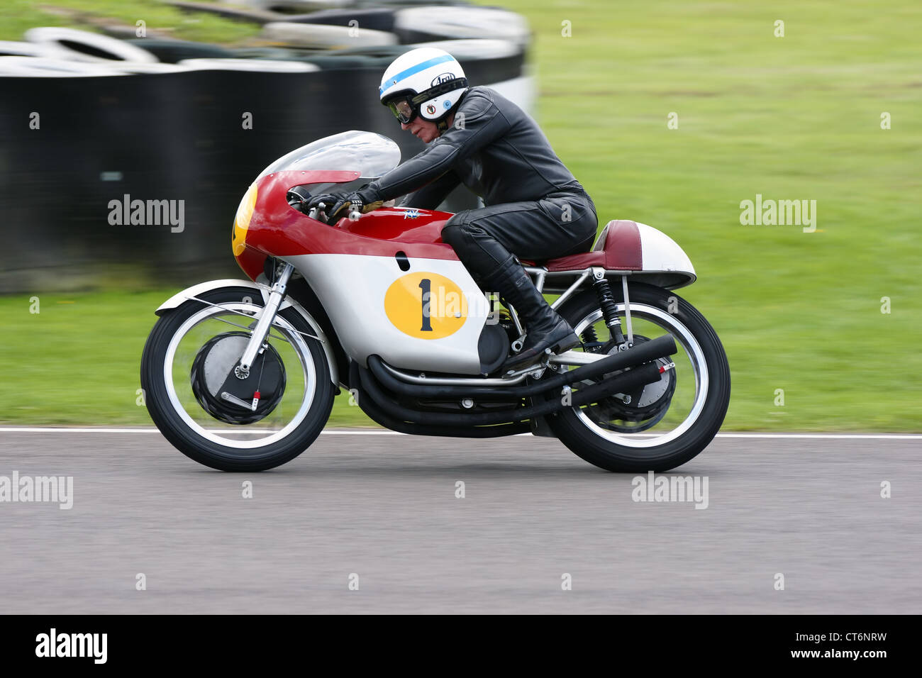 Motorsport legend John Surtees, the only man to be world champion on two wheels and four, demonstrating at the Goodwood Revival Stock Photo