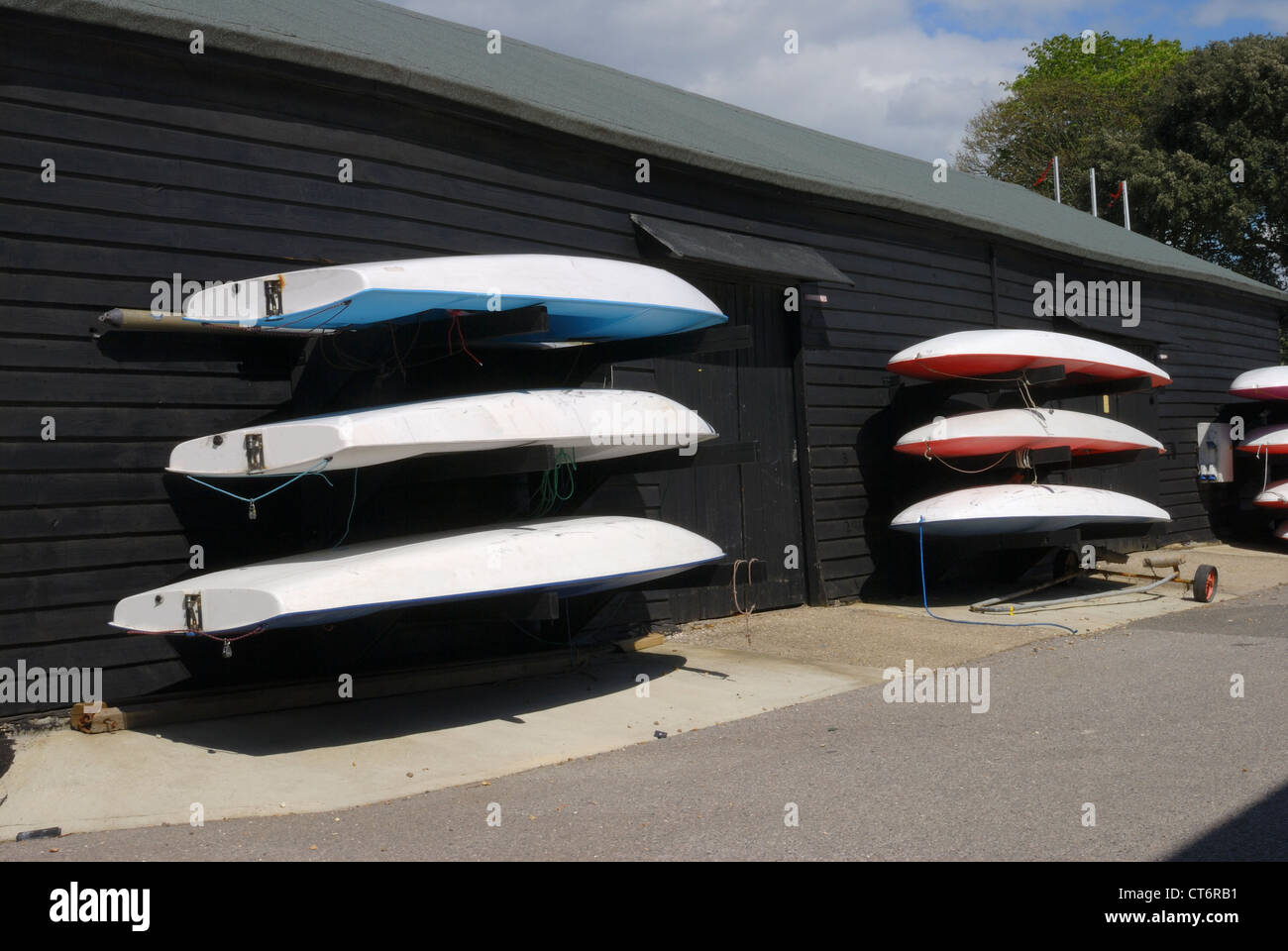 Racing dingies on wooden wall of boathouse at Dell Quay. Chichester Harbour. West Sussex. England Stock Photo