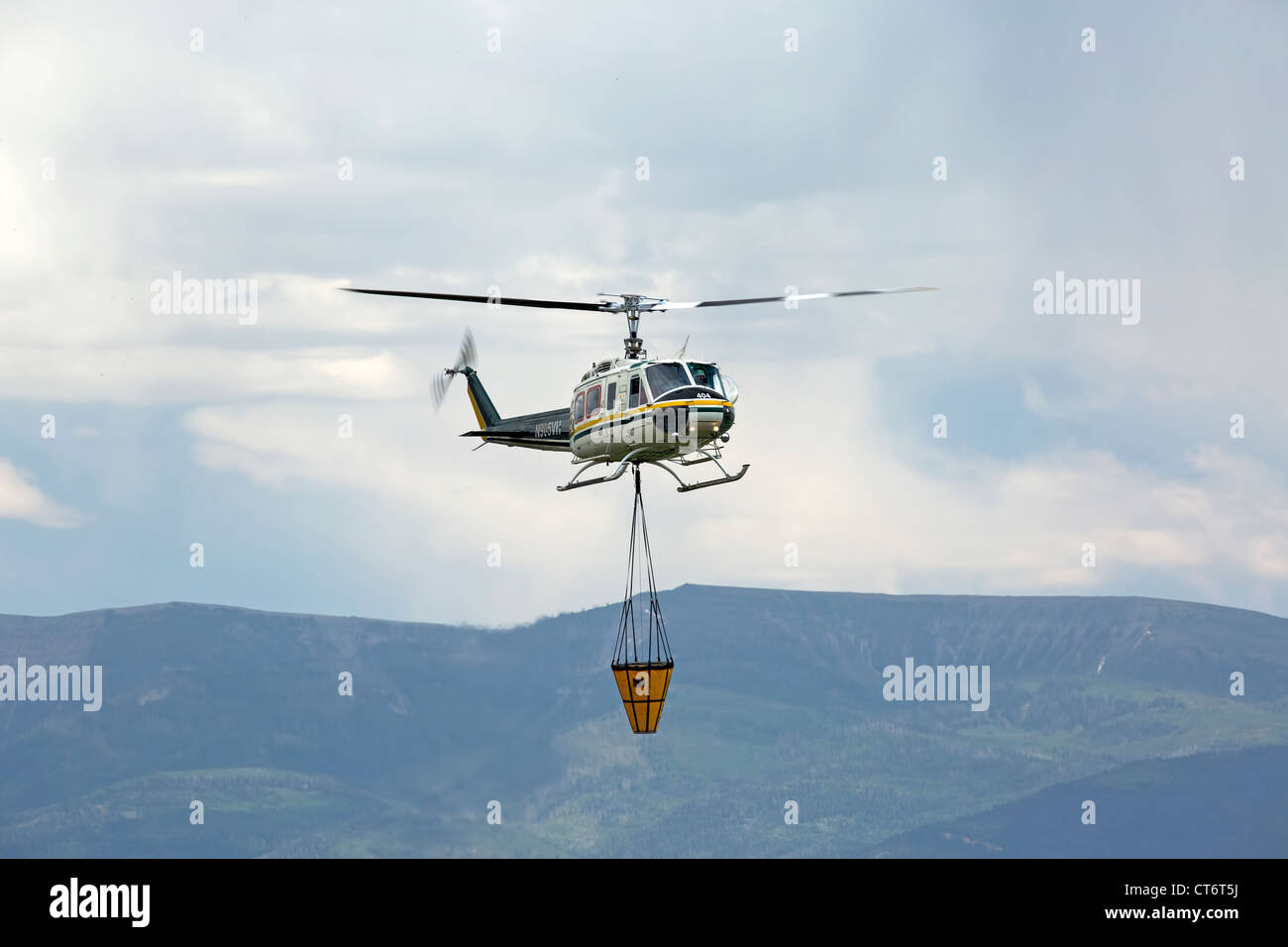 A firefighter helicopter rushes to help put out a wildfire, carrying a