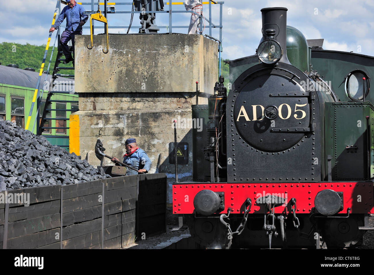 Men loading coal as fuel for steam train at the depot of the Chemin de